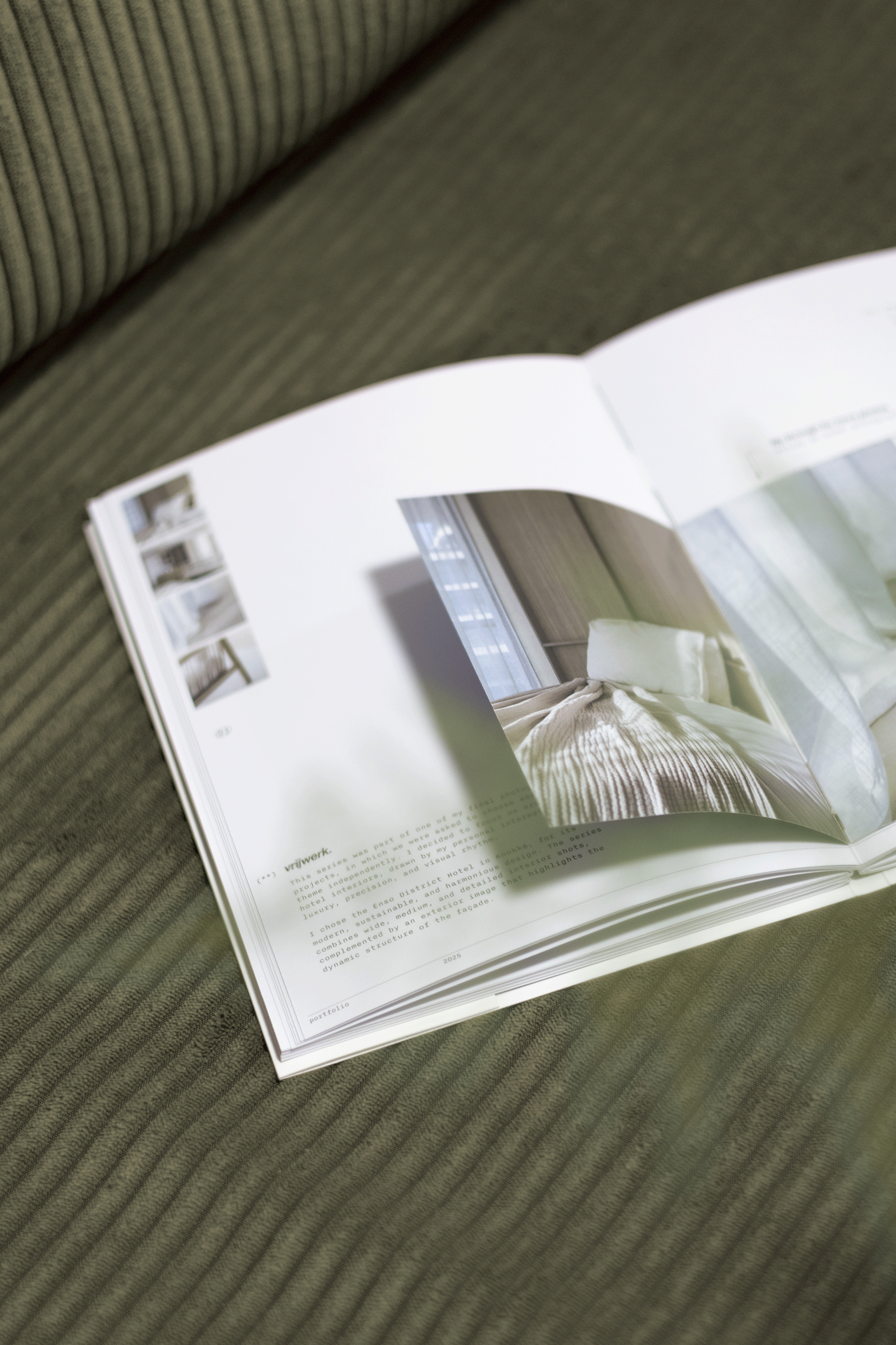 Open magazine with interior images of a bedroom, resting on a green striped fabric surface.