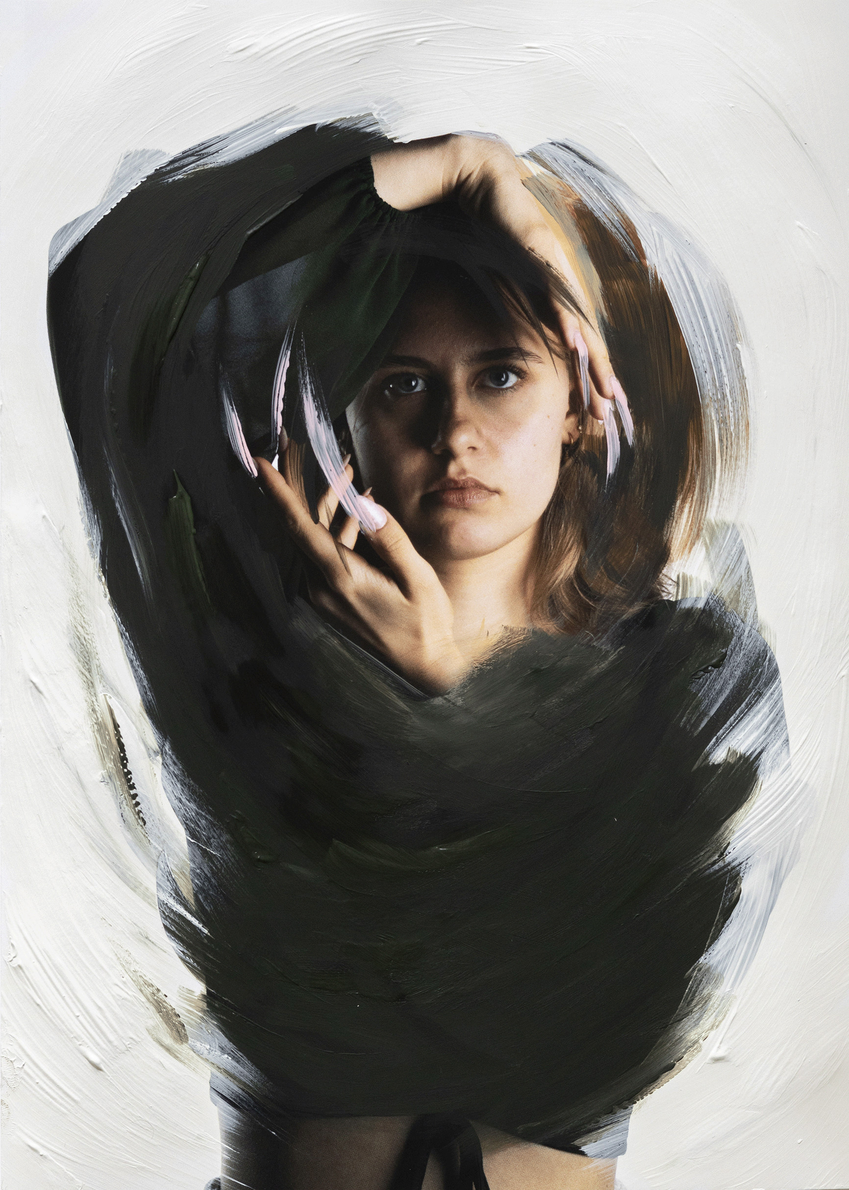 A woman with short brown hair and blue eyes looking directly at the camera, partially obscured by abstract brush strokes of black, white, brown, and pink paint on a canvas.
