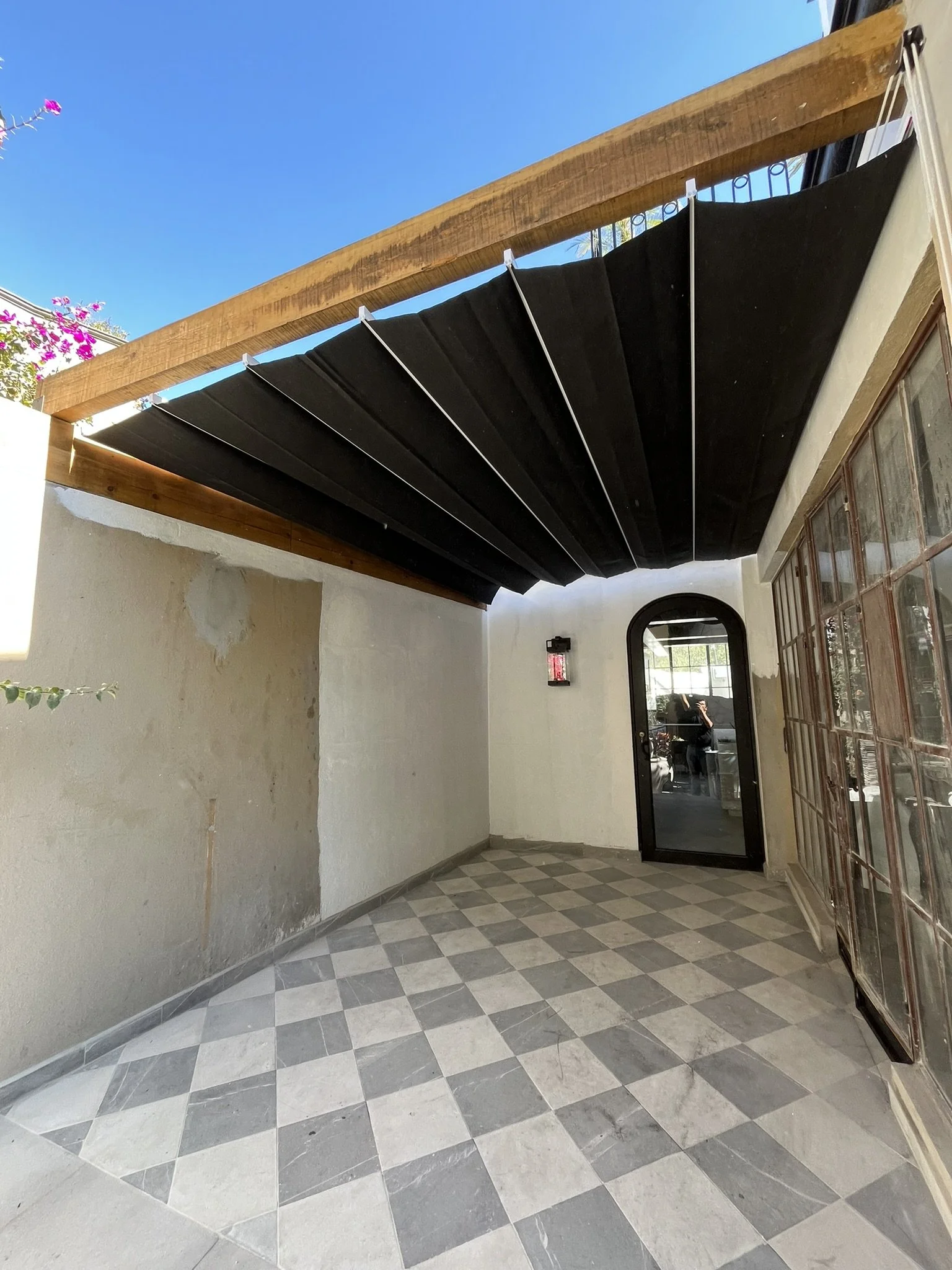 Interior de una terraza con cubierta con una estructura de madera y sobre esta se ve instalado un techo retrácitl o canopie.