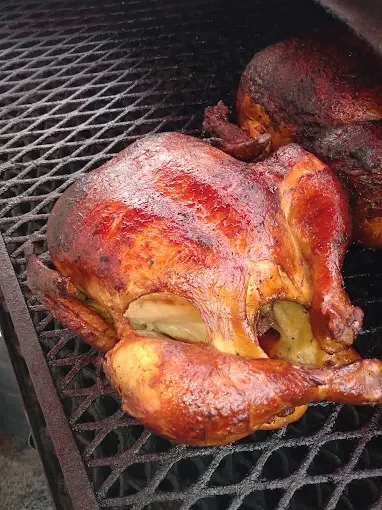 A roasted whole chicken with crispy skin on a grill