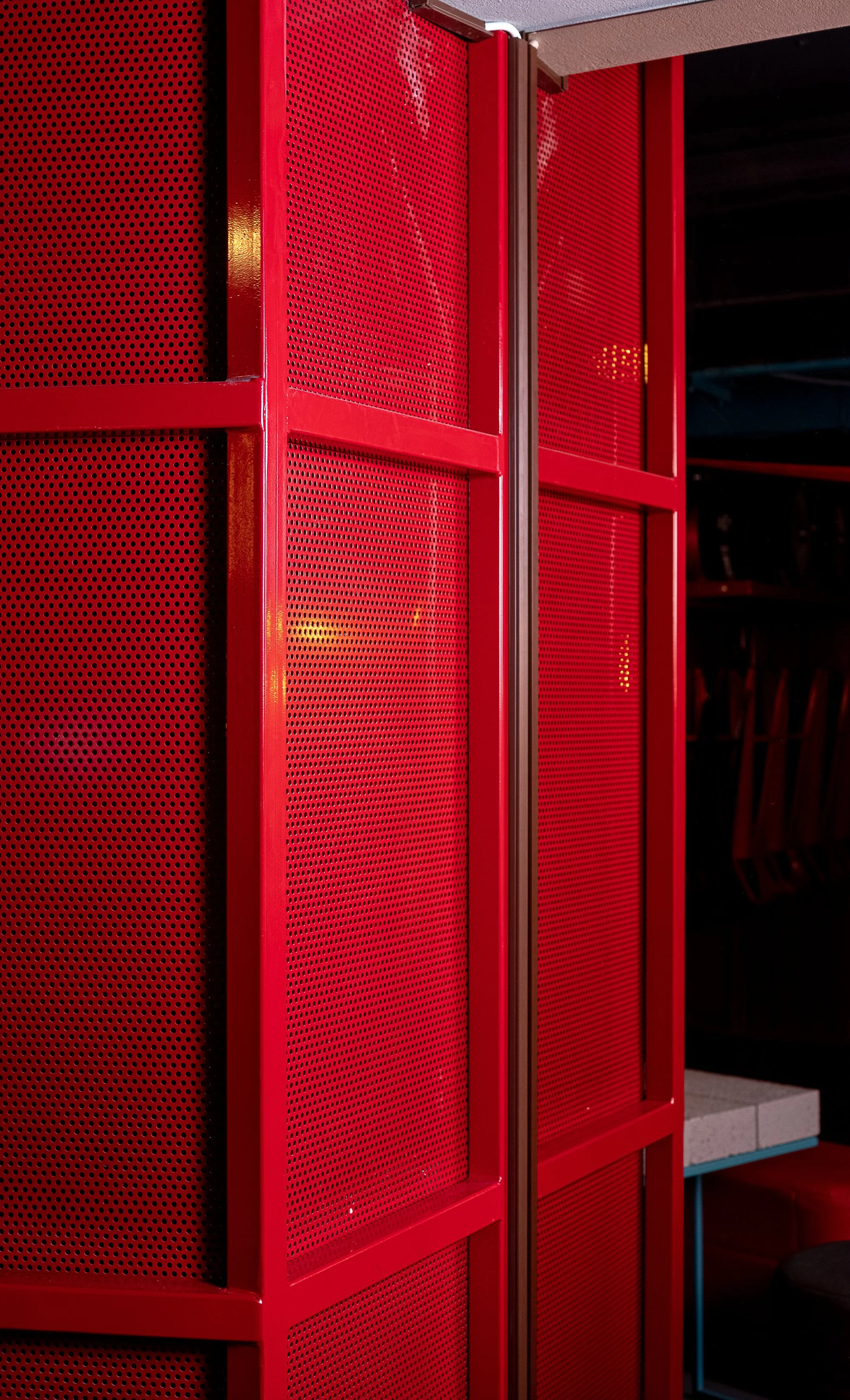 Tapped, Grafton Street, Dublin — Red perforated metal lockers or cabinets with a vertical handle in an indoor setting.