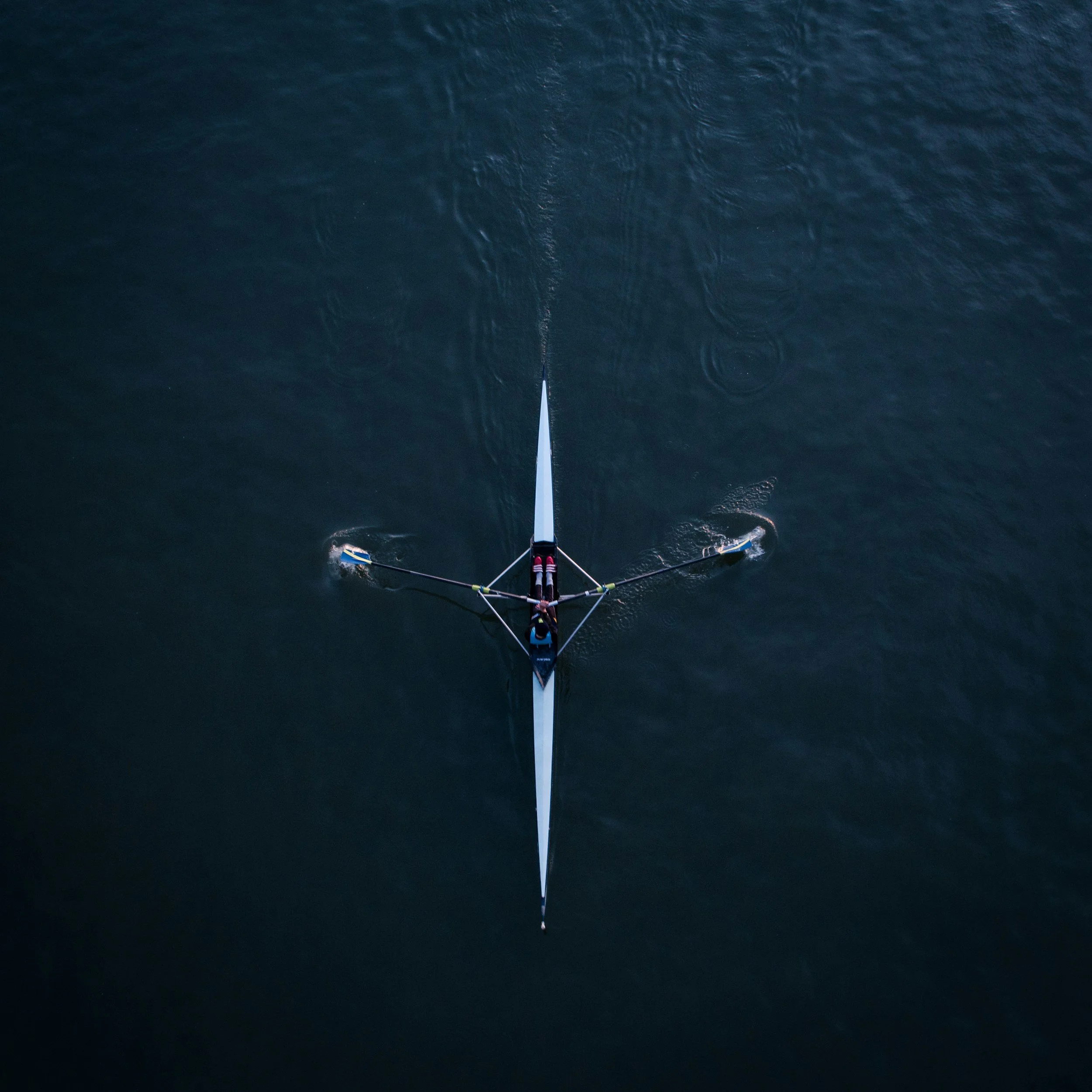 View from a boat or watercraft looking down at the water surface with ripples, and the boat's bow and equipment visible at the bottom of the frame.