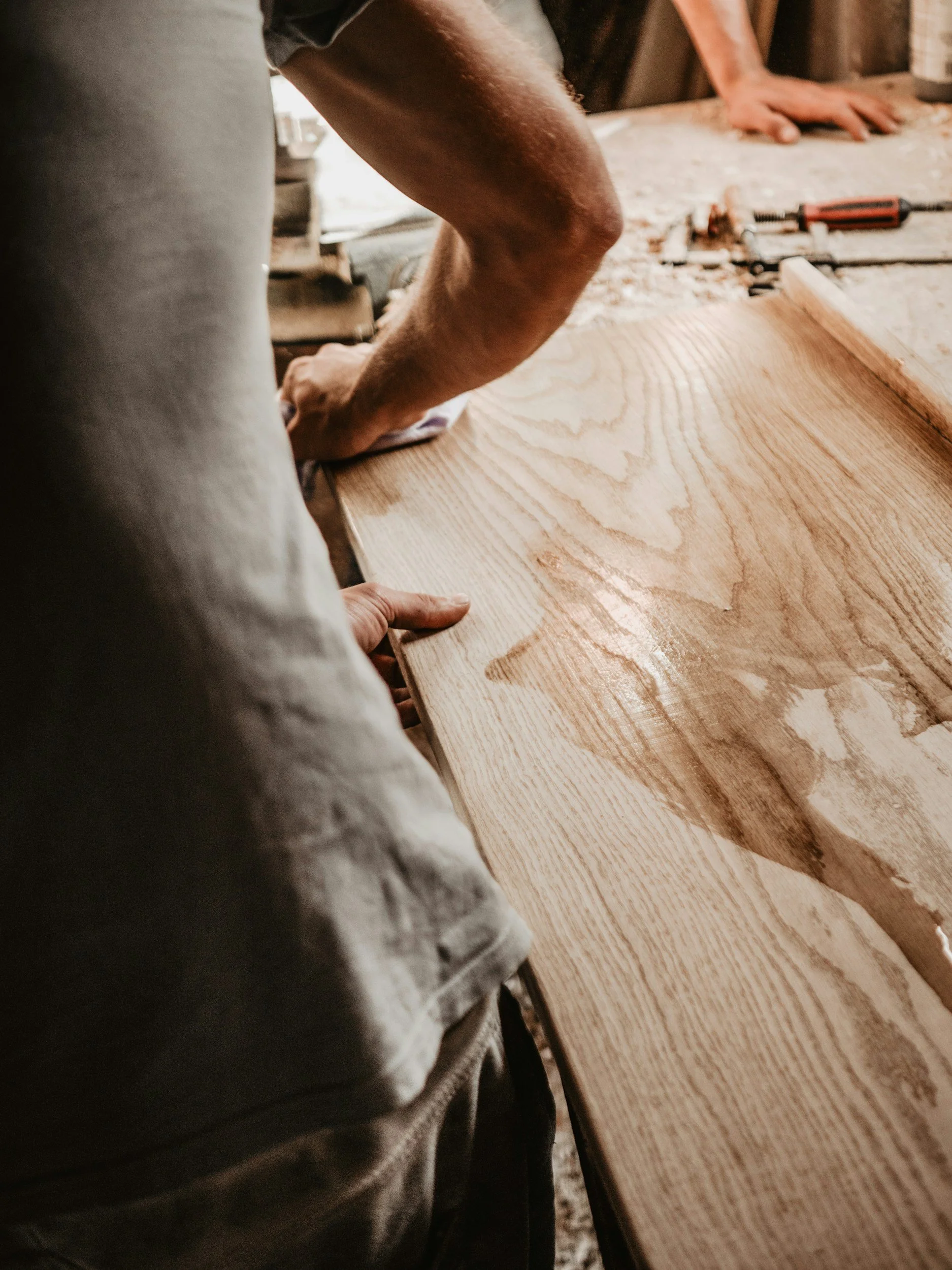 TW Floors craftsman working by hand on a custom hardwood flooring detail.