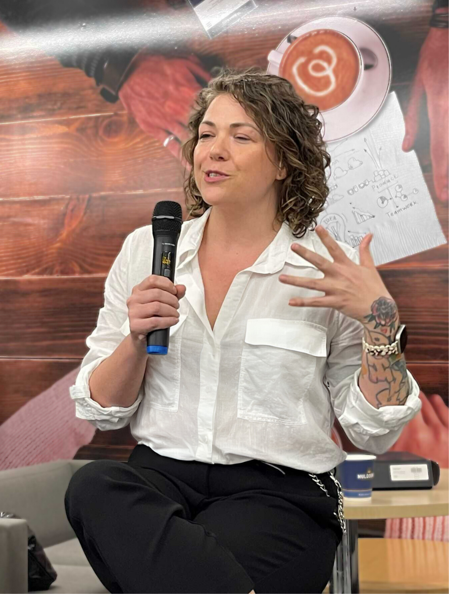 A photo of ZJ Hadley holding a microphone at a speaking event. Even in still, she looks eloquent.