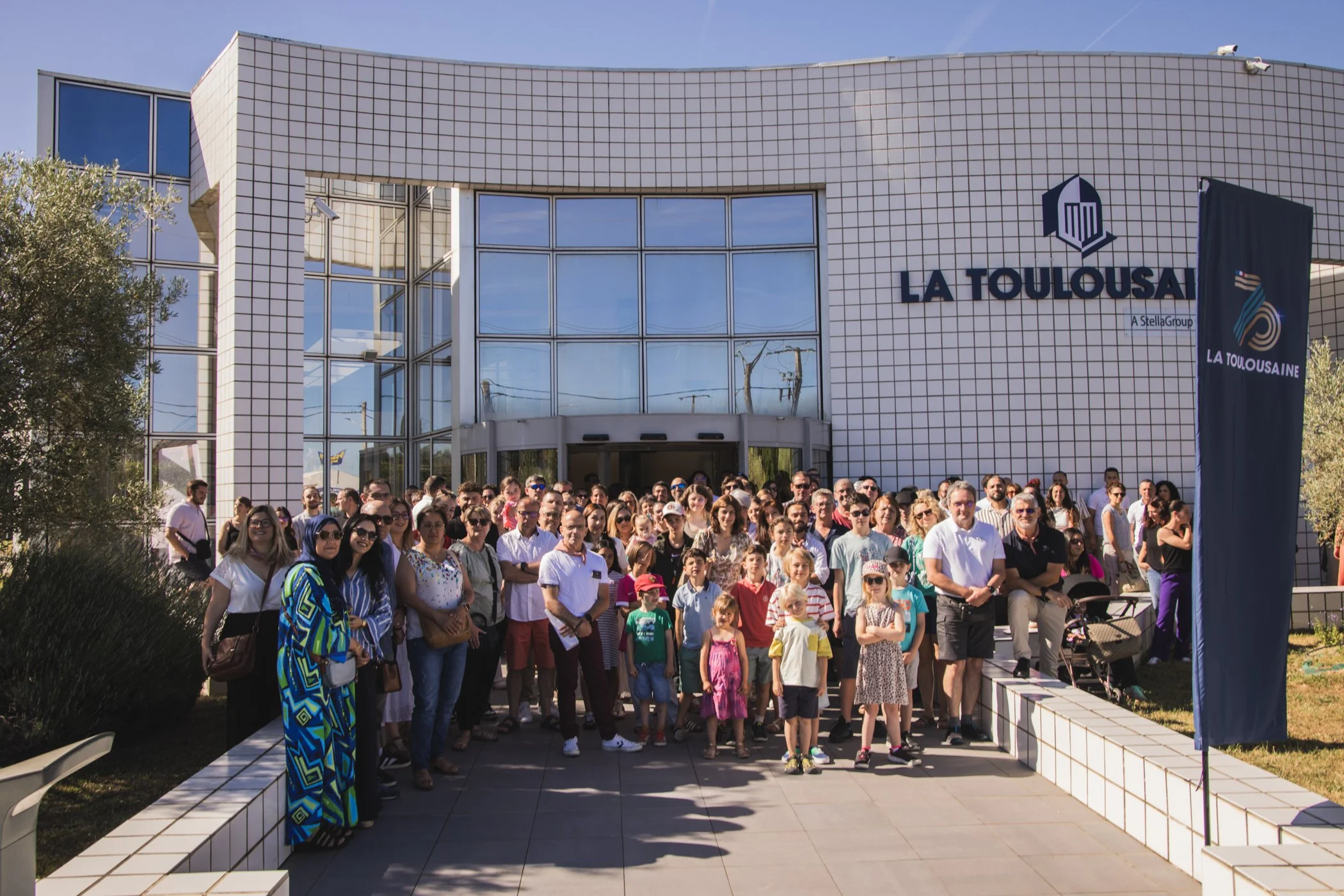 Groupe de personnes posant devant le bâtiment La Toulouseine.