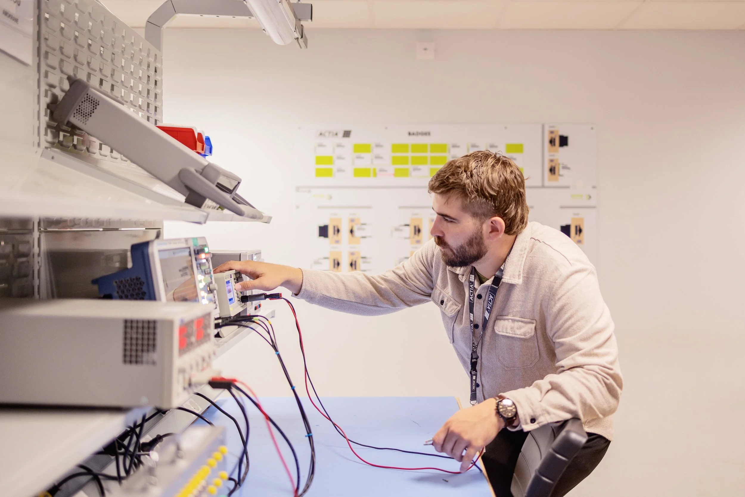 Un homme travaille dans un laboratoire avec des équipements électroniques et des outils, concentré sur un proyecto technique.