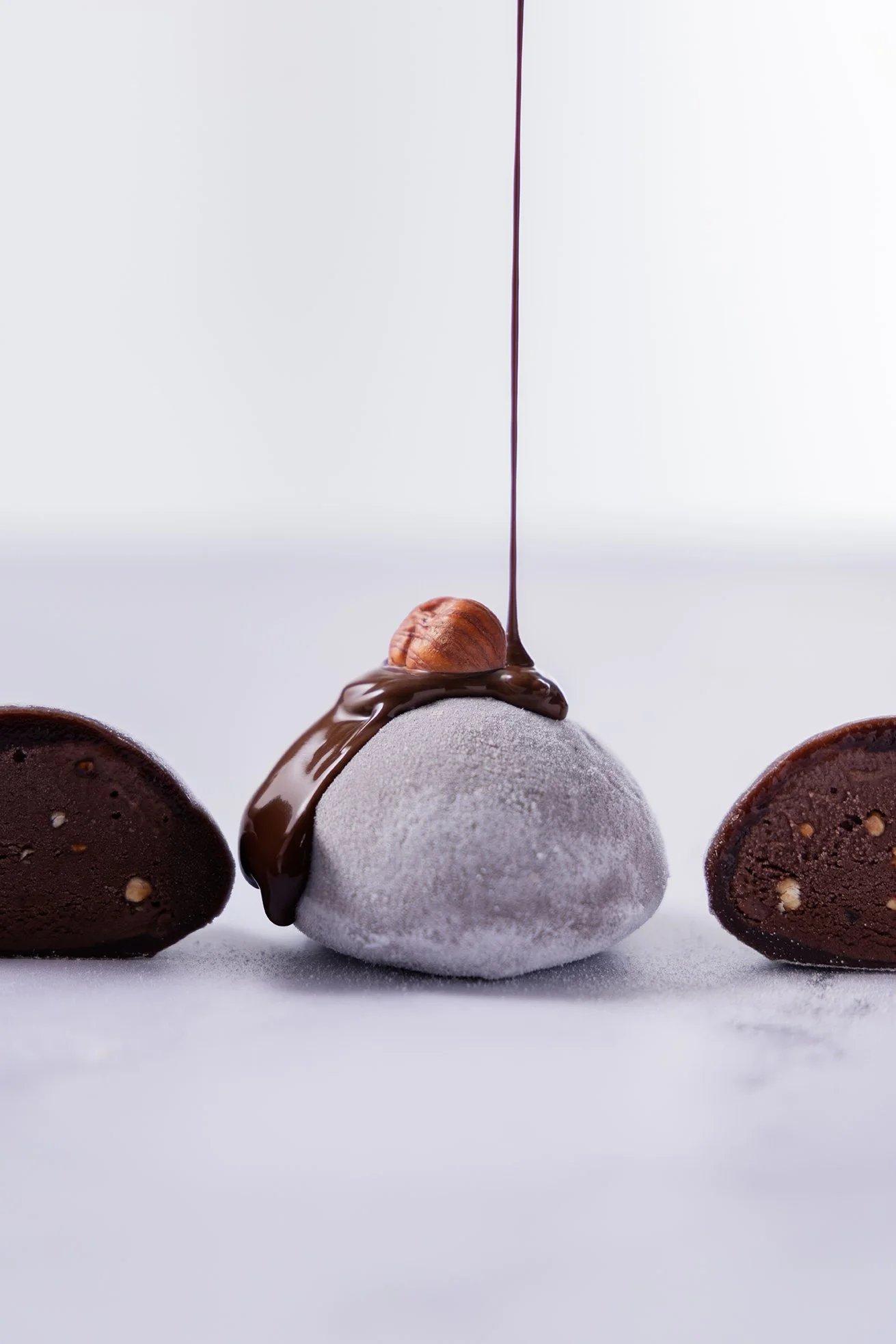 Mendiant en chocolat blanc avec noisette, entre deux moitiés de chocolat noir.