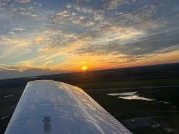 Sunset viewed from an airplane window with part of the wing visible