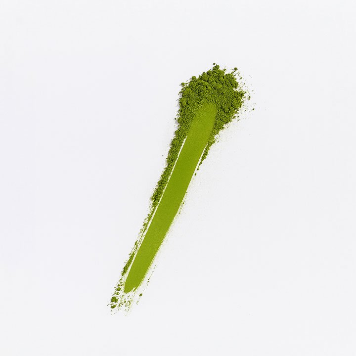 A matchstick with green powder on the head, resembling moss or a plant.