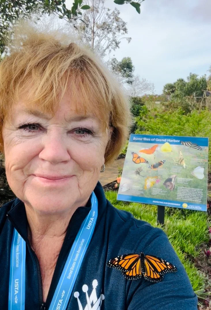 Debbie Lindsey with a monarch butterfly at the Audubon Garden at Grand Harbor in Vero Beach, Florida, where she raised and released monarchs using milkweed and protected enclosures