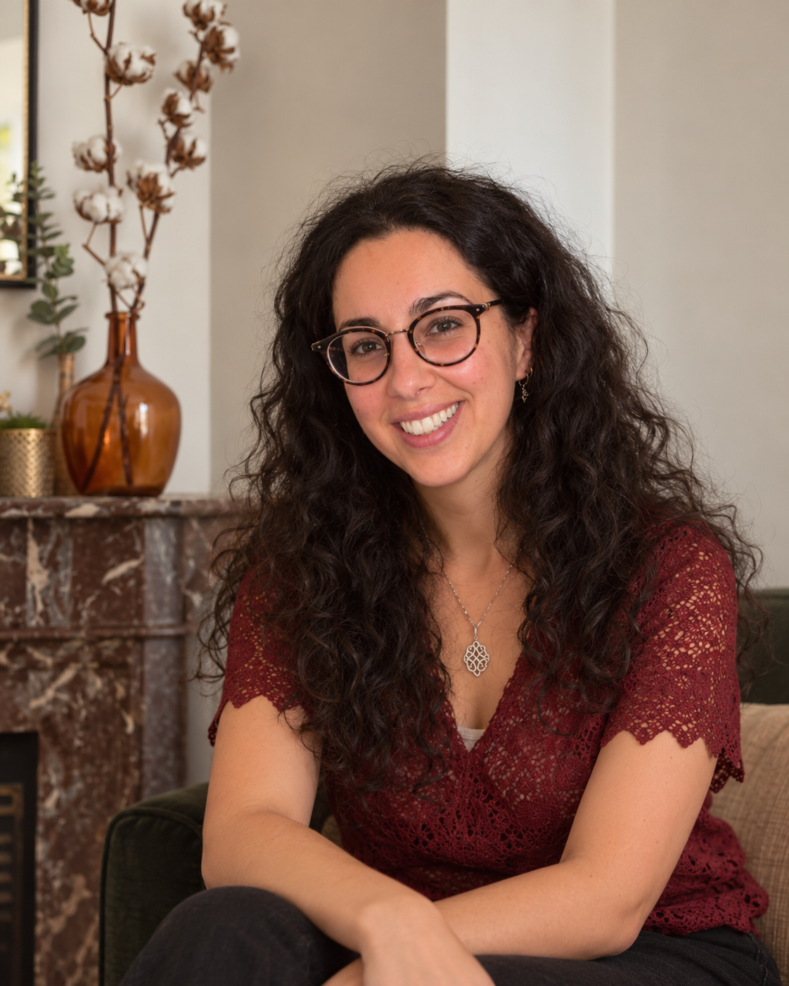 Portrait souriant de Cécilia Elbaz, psychopraticienne et naturopathe à Levallois-Perret, près des branches de coton.