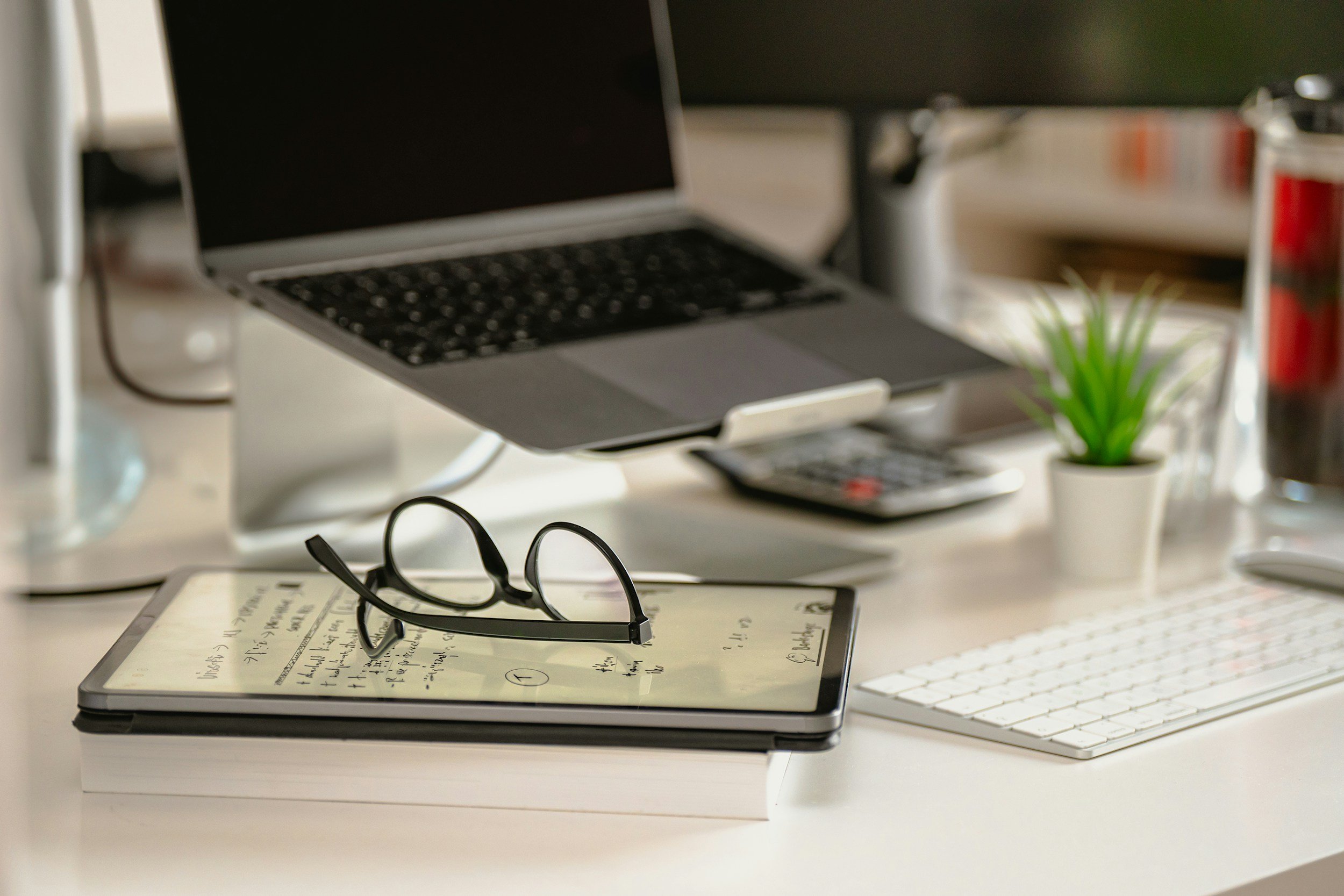 Bookkeeping workspace with laptop, calculator, and financial notes