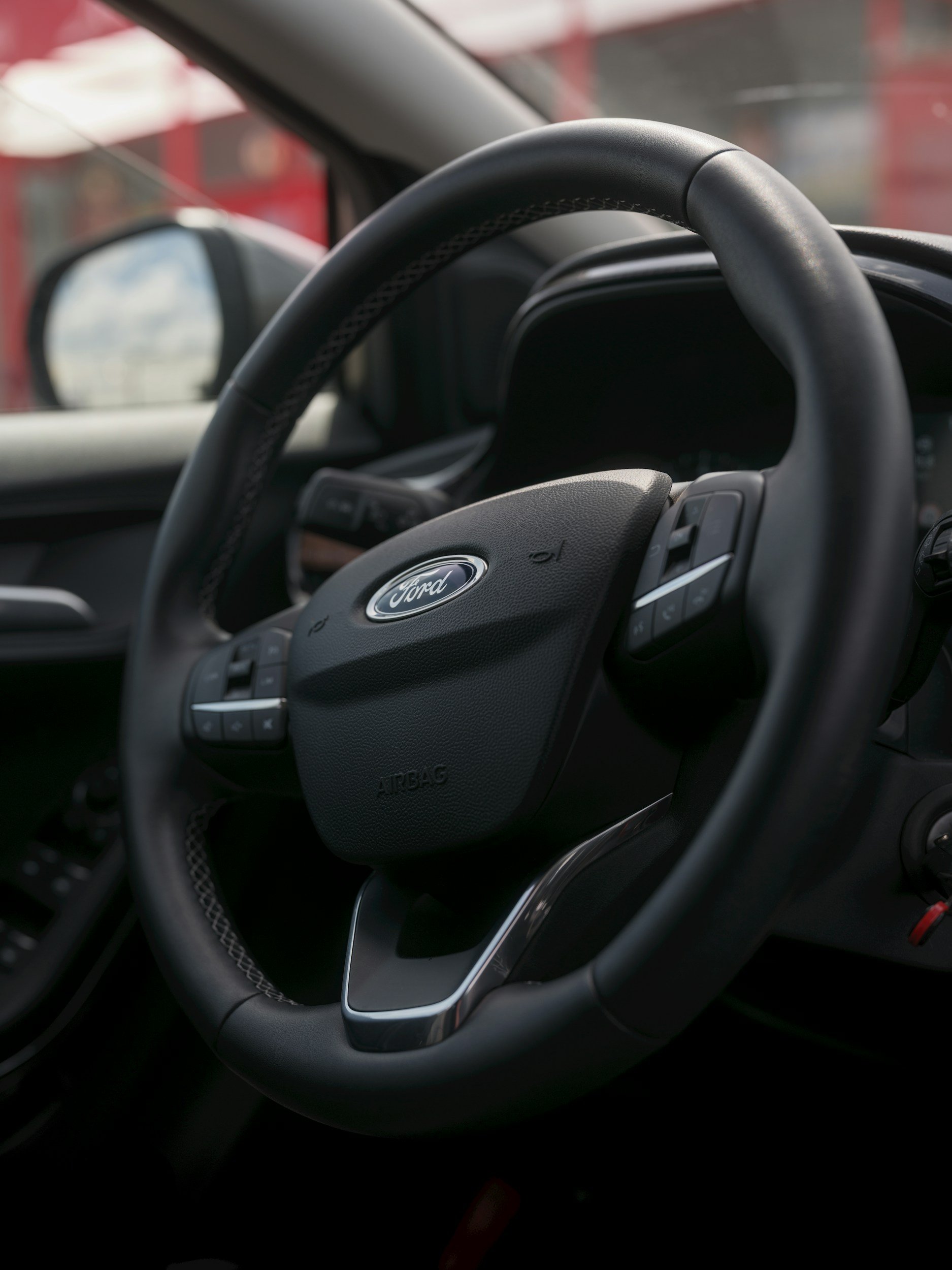 Close-up of a Ford car steering wheel inside a vehicle.
