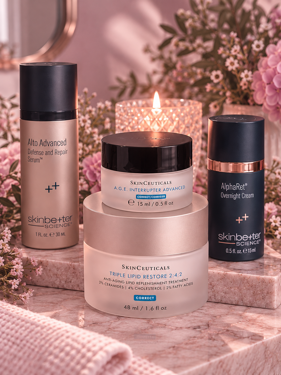 Skincare products on pink marble surface, including Alto Advanced Defense and Repair Serum, A.G.E. Interrupter Advanced, Triple Lipid Restore, and AlphaRet Overnight Cream, surrounded by pink flowers and a lit candle in the background.