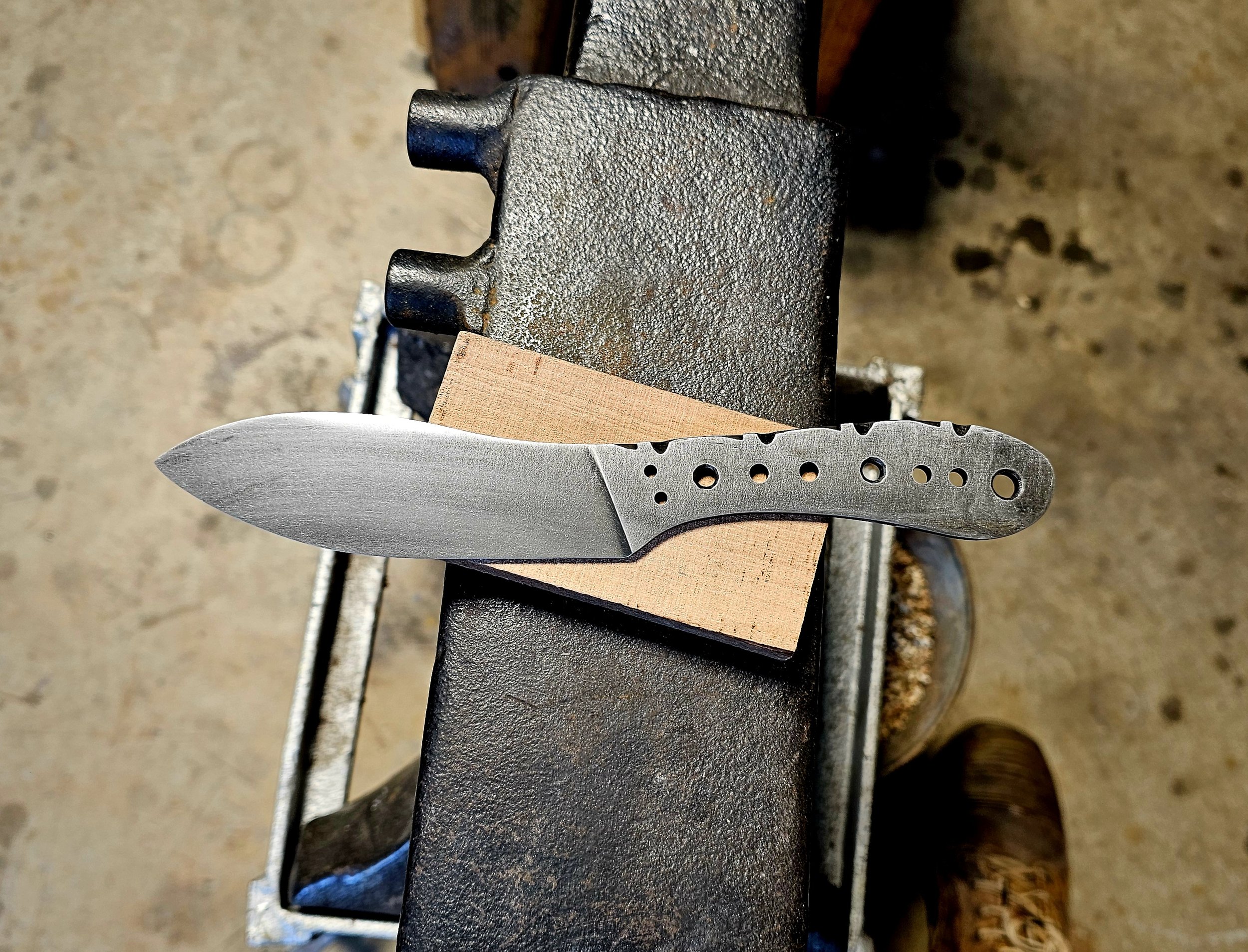 A blacksmith's workbench holds a partially crafted Nesmuk style knife