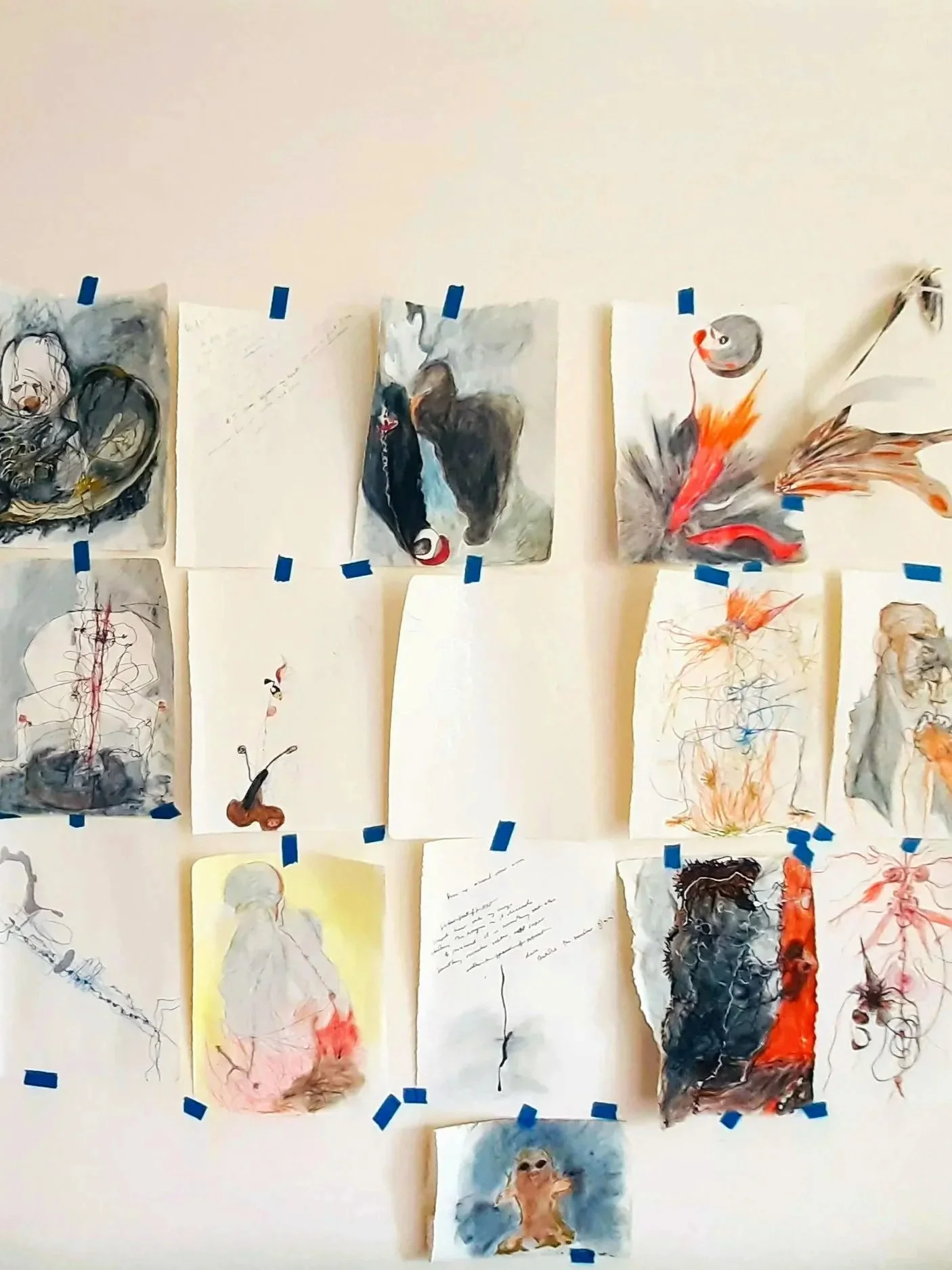 Collection of drawings, writing and paintings of various animals, mythic image, archetypal images taped to a white wall.