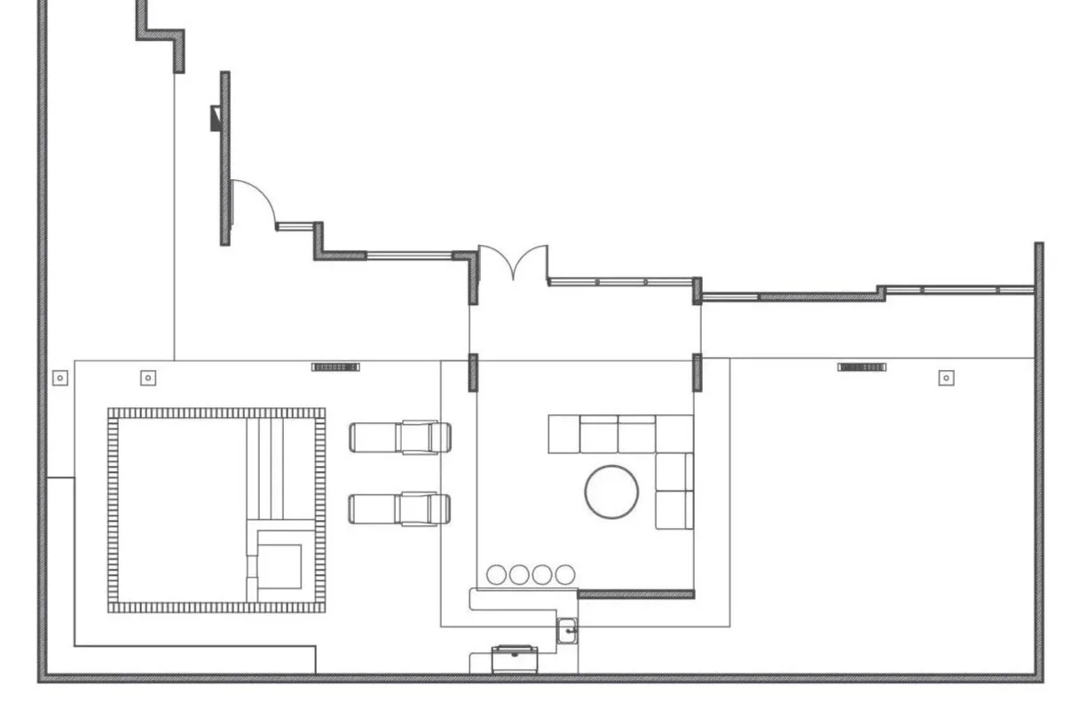 A floor plan of a house showing a garage with two cars, an open living area with a sectional sofa and round coffee table, a separate enclosed room, and an entryway with double doors.