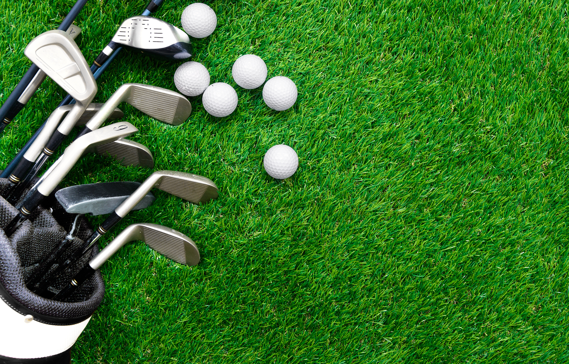 Golf clubs and golf balls on the grass