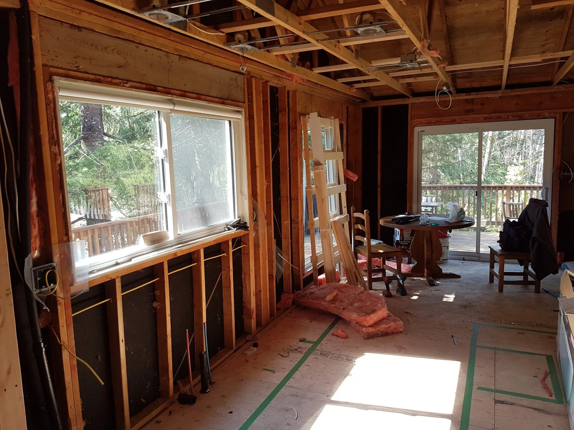 Interior renovation with exposed wall framing, ceiling joists, and wiring in Whistler, BC