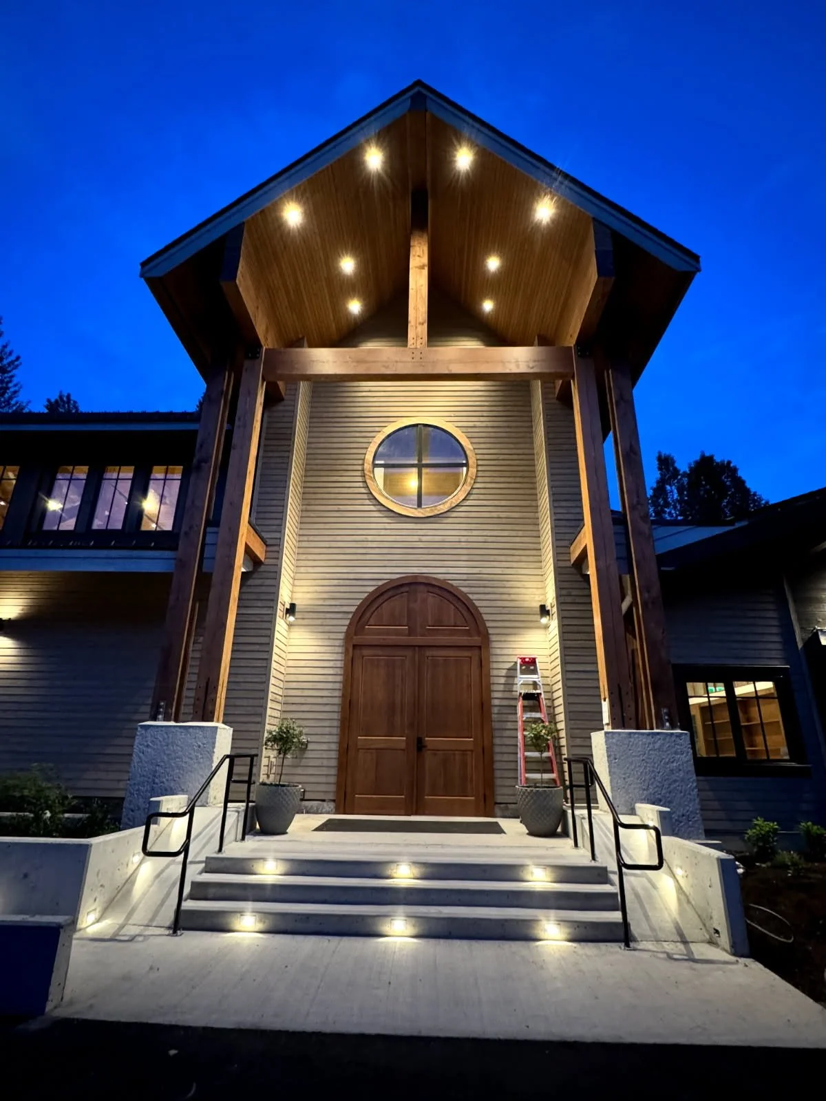 Timber and stone lodge entrance in Whistler lit up at night, showing exterior lighting