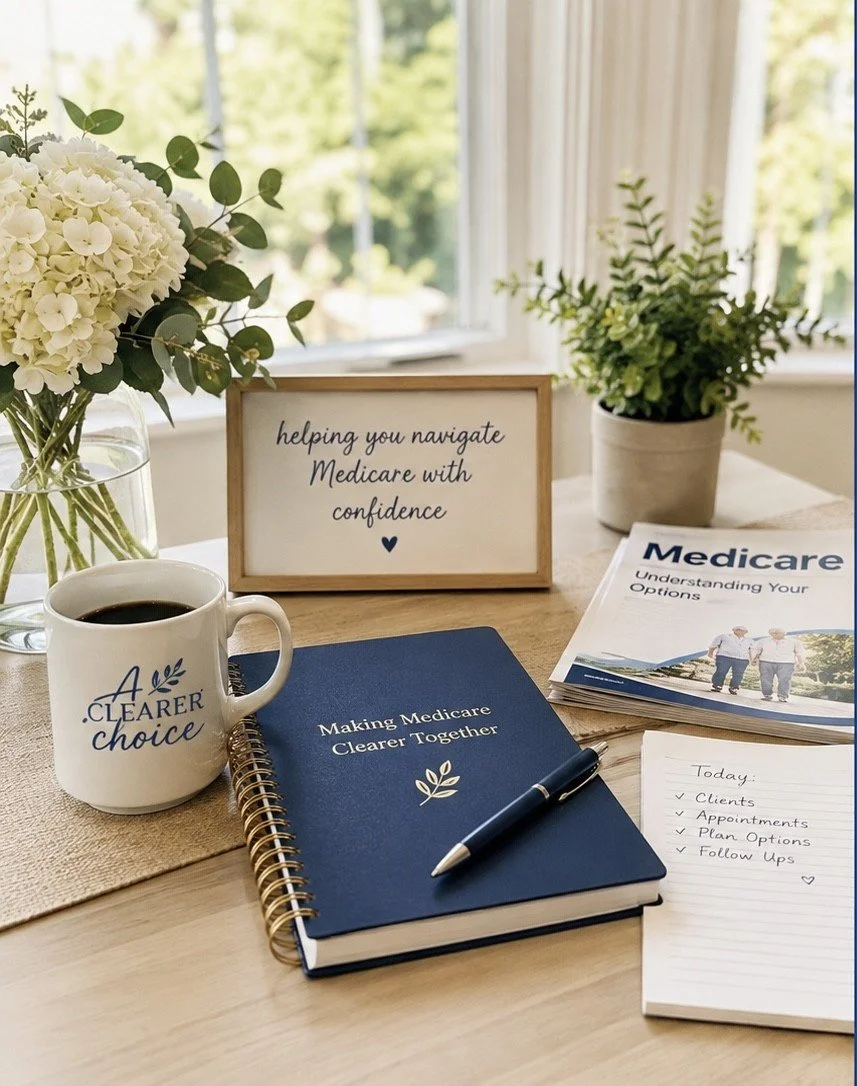 A desk setup with a bouquet of white flowers in a glass vase, a potted green plant, a coffee mug with the words "A Clearer Choice," a spiral-bound notebook titled "Making Medicare Clearer Together," a pen, and pamphlets about Medicare. There is also a small sign that reads "helping you navigate Medicare with confidence" and a notepad with a list of tasks for the day.