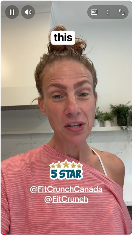 A woman with red hair in a messy bun, wearing a pink and white top, appears to be speaking or giving a testimonial. There are some green plants in the background, and text overlays include 'this' and '5 STAR', along with social media tags '@FitCrunchCanada' and '@FitCrunch'.