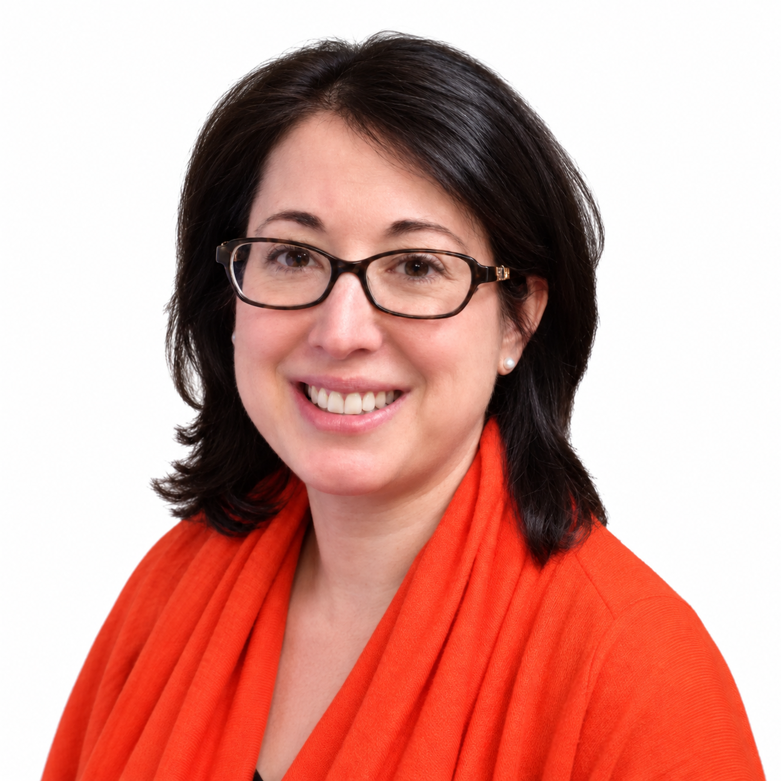 Portrait of a woman with dark brown hair, glasses, earrings, wearing an orange scarf and blazer, smiling against a white background.