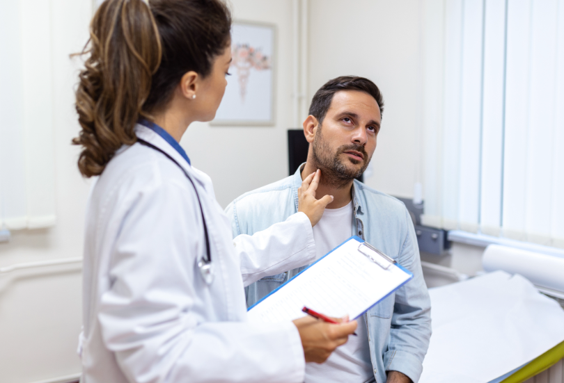 Doctor examining a male patient in a consultation room.