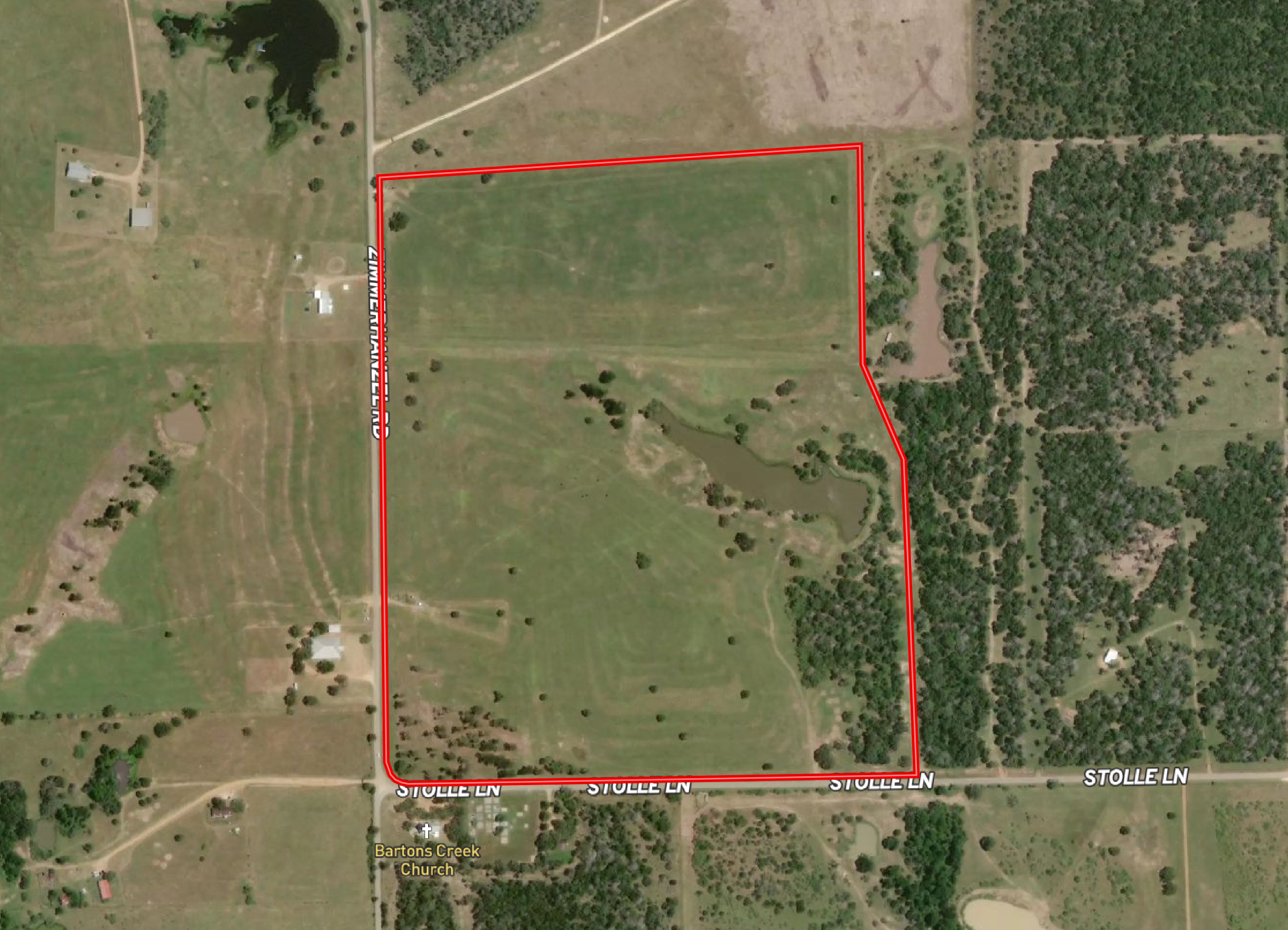 Aerial view of a large rectangular field outlined in red, with trees, a pond, and scattered buildings nearby, with the road labeled Stolle Lane at the bottom.