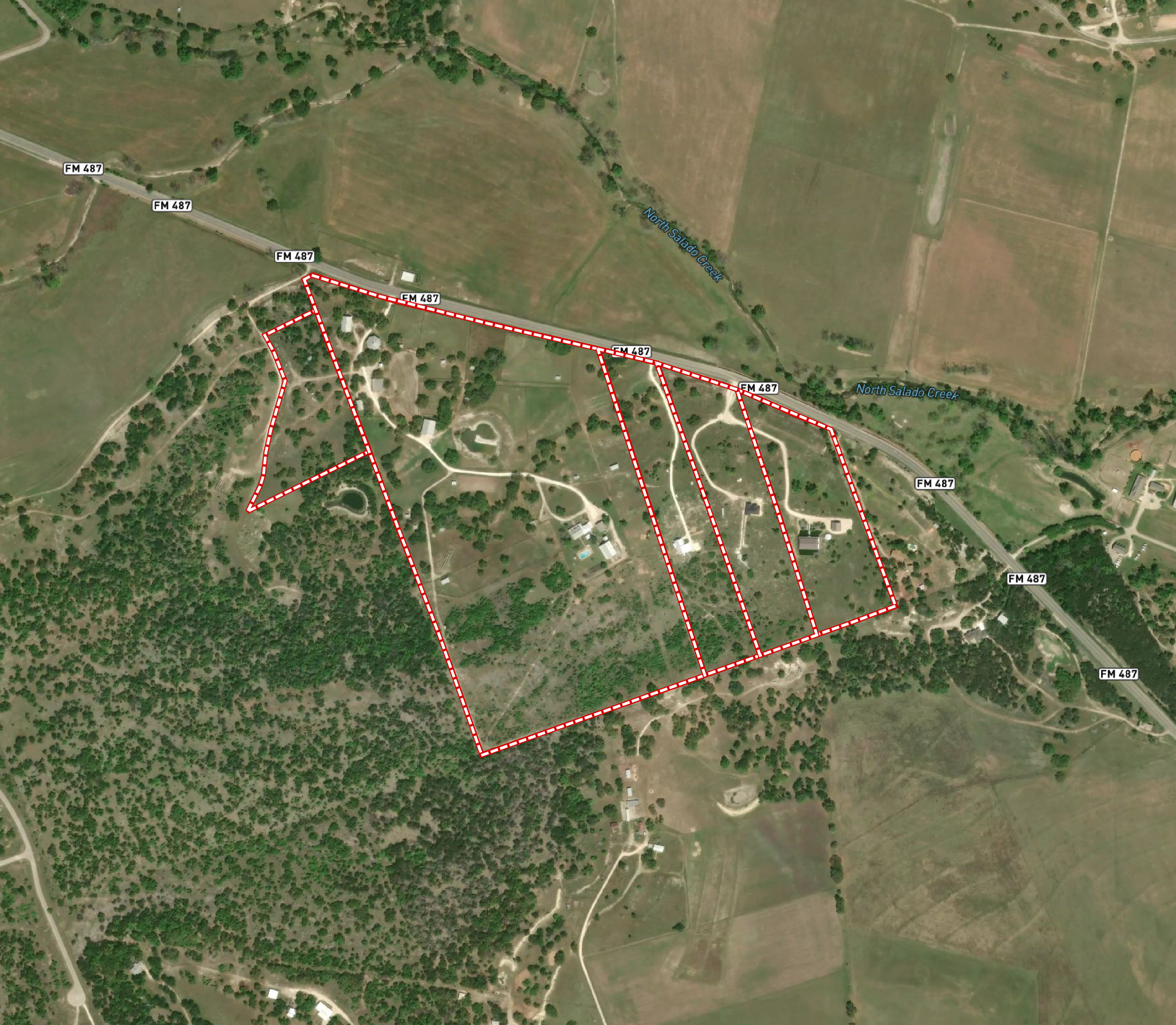 Satellite view of a rural area with roads, wooded patches, and open fields. There's a creek labeled North Salado Creek running through the area. Red dashed lines indicate property boundaries or designated areas.