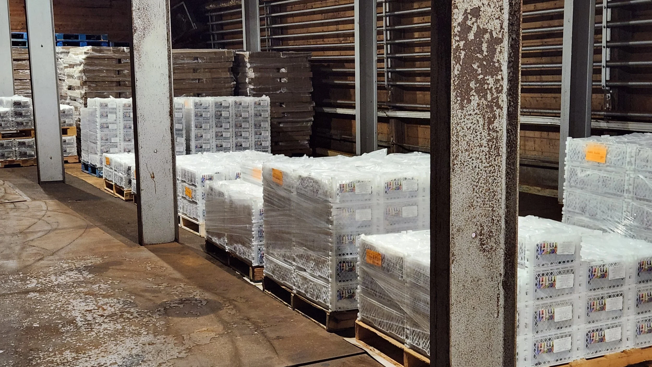 Pallets of boxed wine juice pails and supplies in storage
