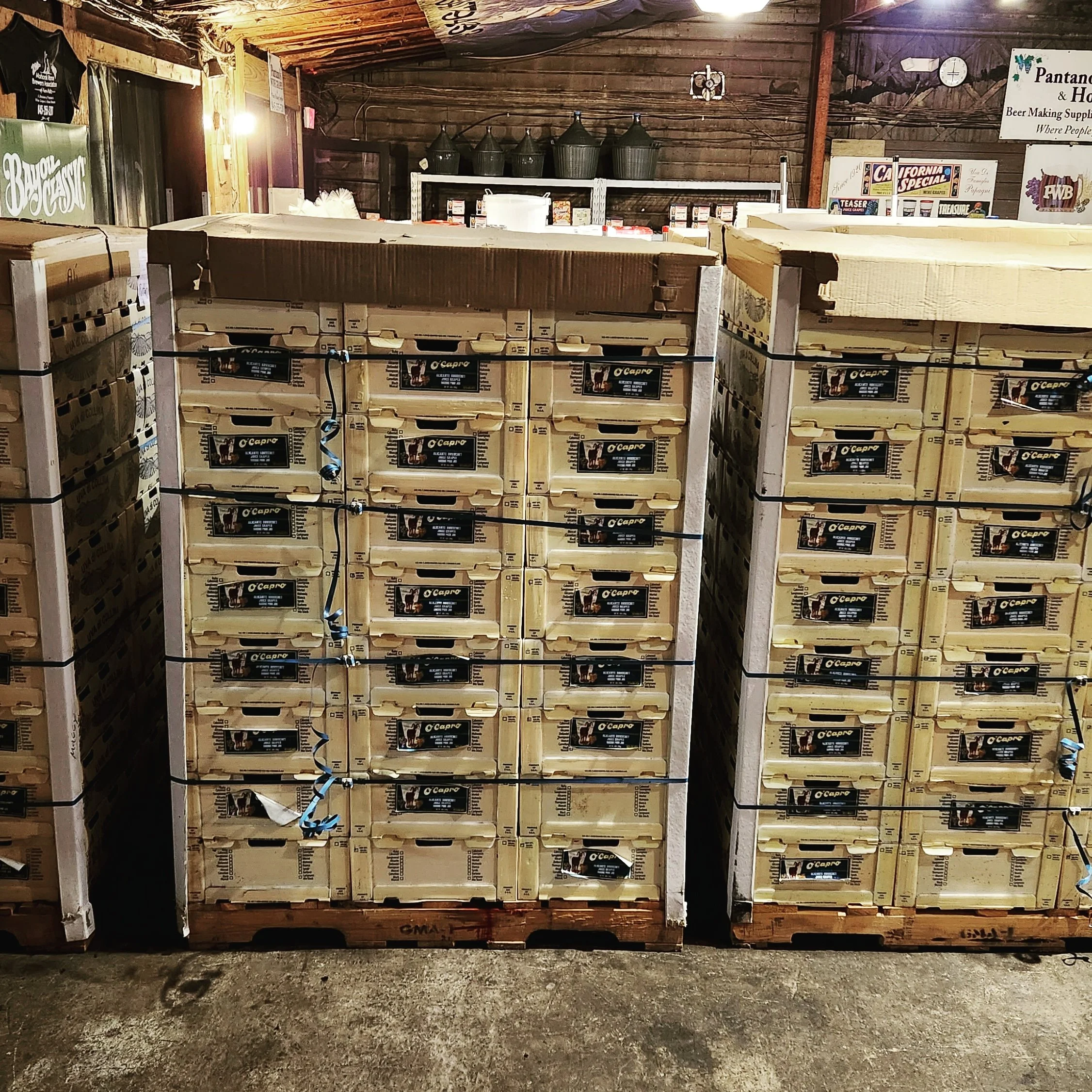 Stacked cardboard boxes on wooden pallets inside a warehouse or storage area.