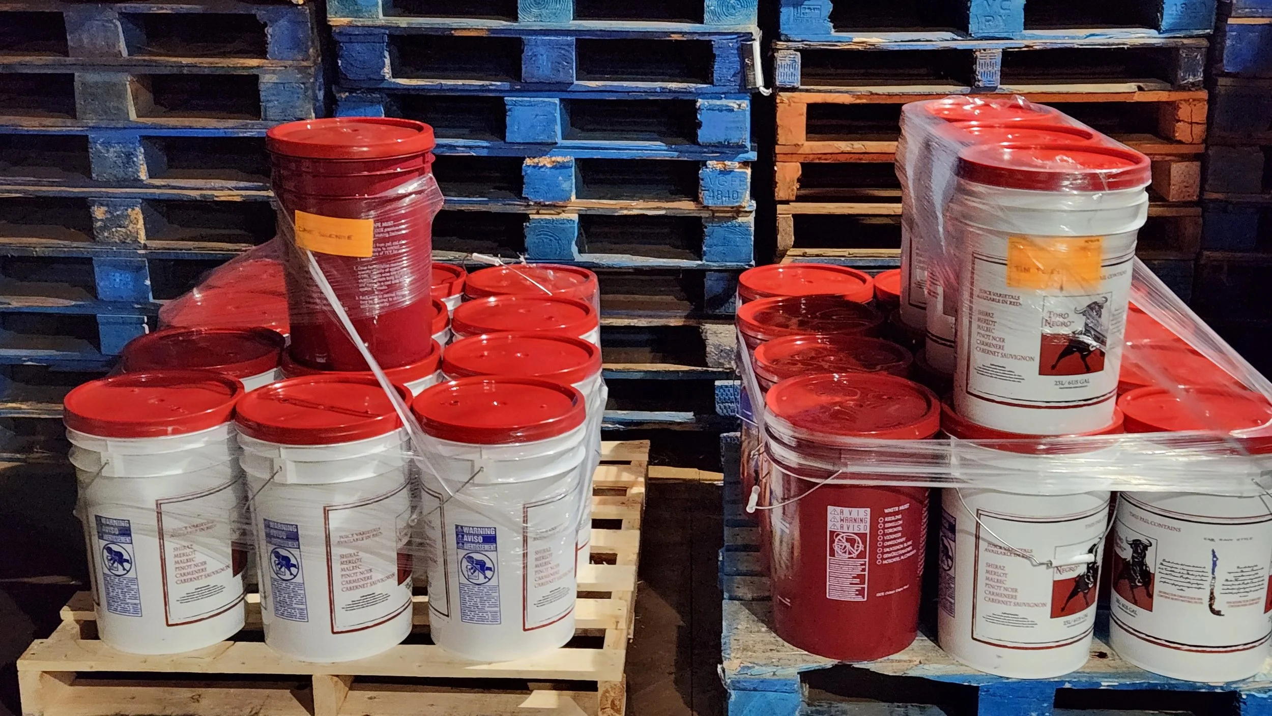 Red and white wine juice pails stacked for winemaking season