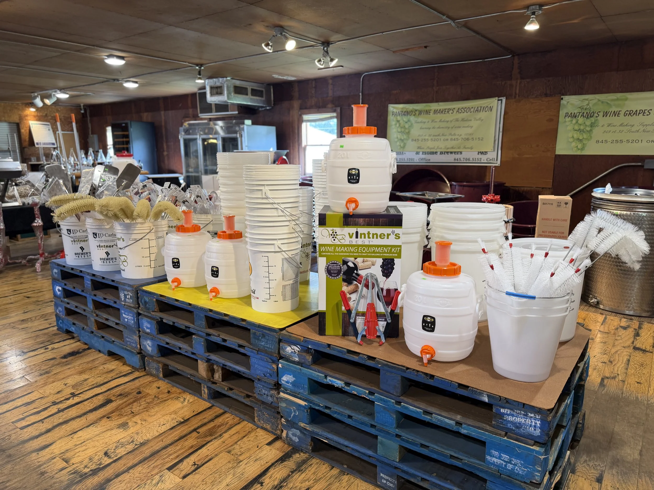 White fermenters, buckets, and winemaking supplies at Pantano's
