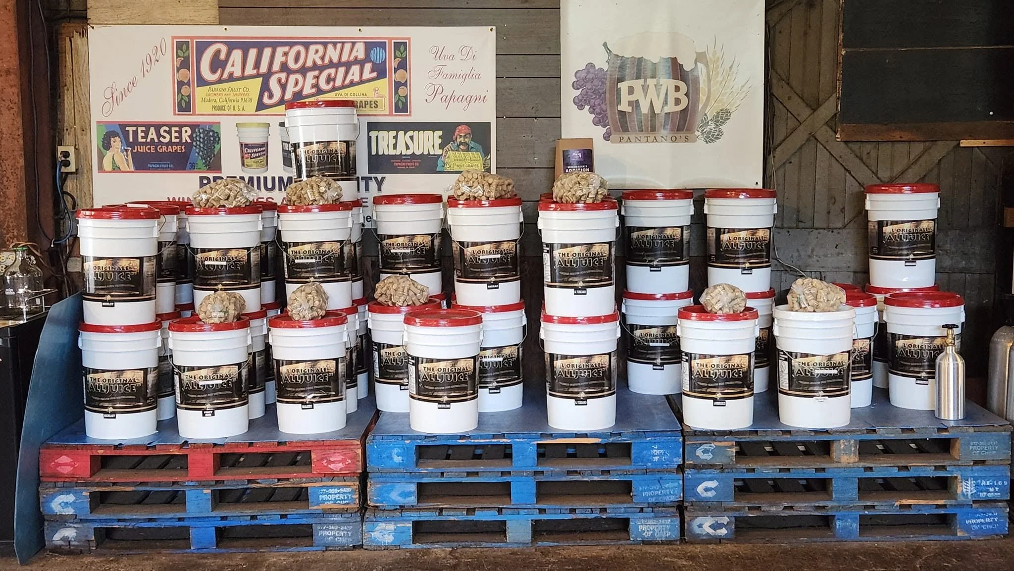Wine juice pails and jars stacked on pallets at Pantano's