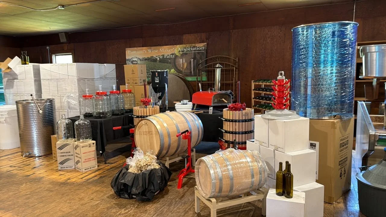 A display of wine-making equipment including barrels, bottles, boxes, and other supplies in a room at Patalto's Wine Maker Association.