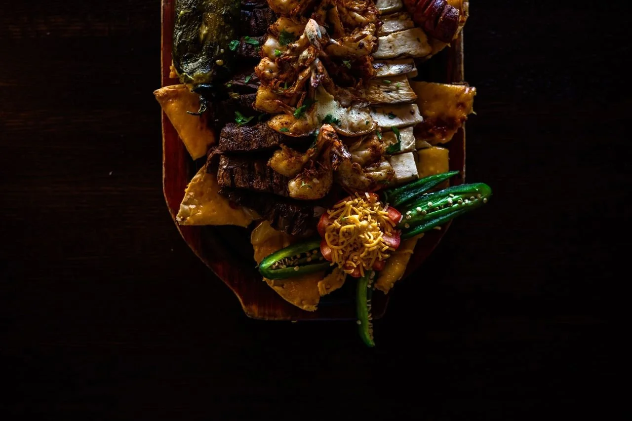 Assorted grilled meats and vegetables on a dark wooden table