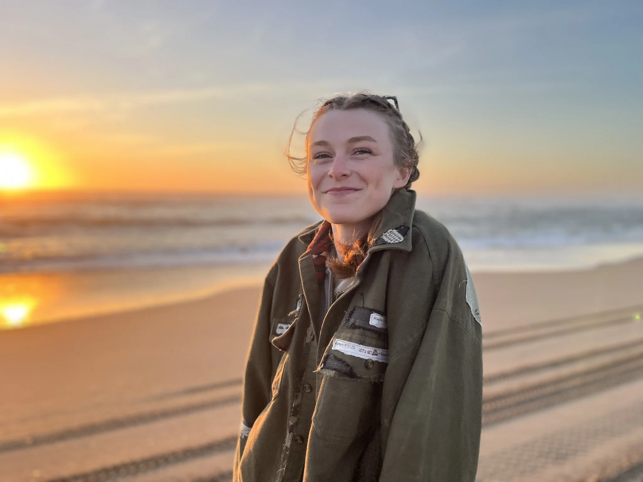 The founder of womb space alignment, rosemary squinting at the camera with a big smile on her face. Excited to share her journey with endometriosis & finding remission.