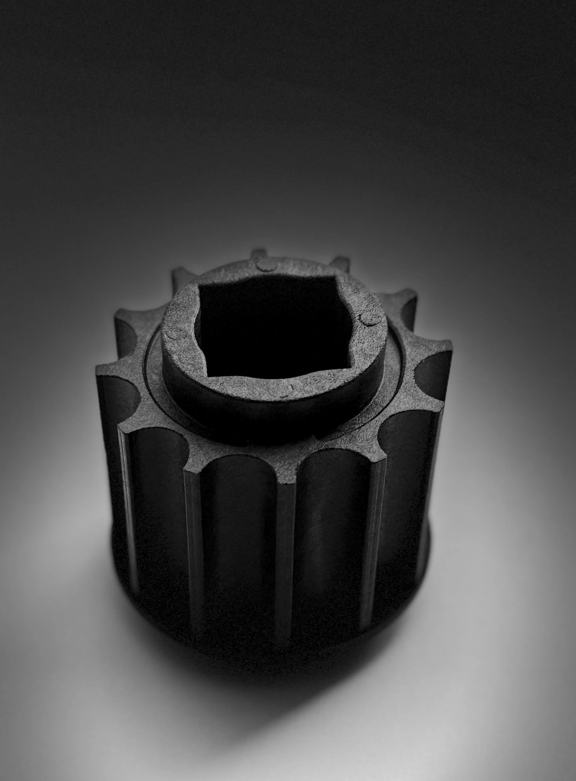 Close-up of a cylindrical object with a textured surface and a hollow center, shot from above, black and white.