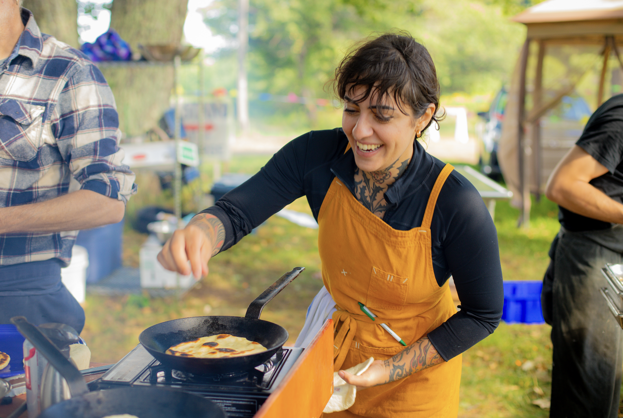 Chef Anna cooking outdoors on a cast iron skillet, private chef Boulder Colorado