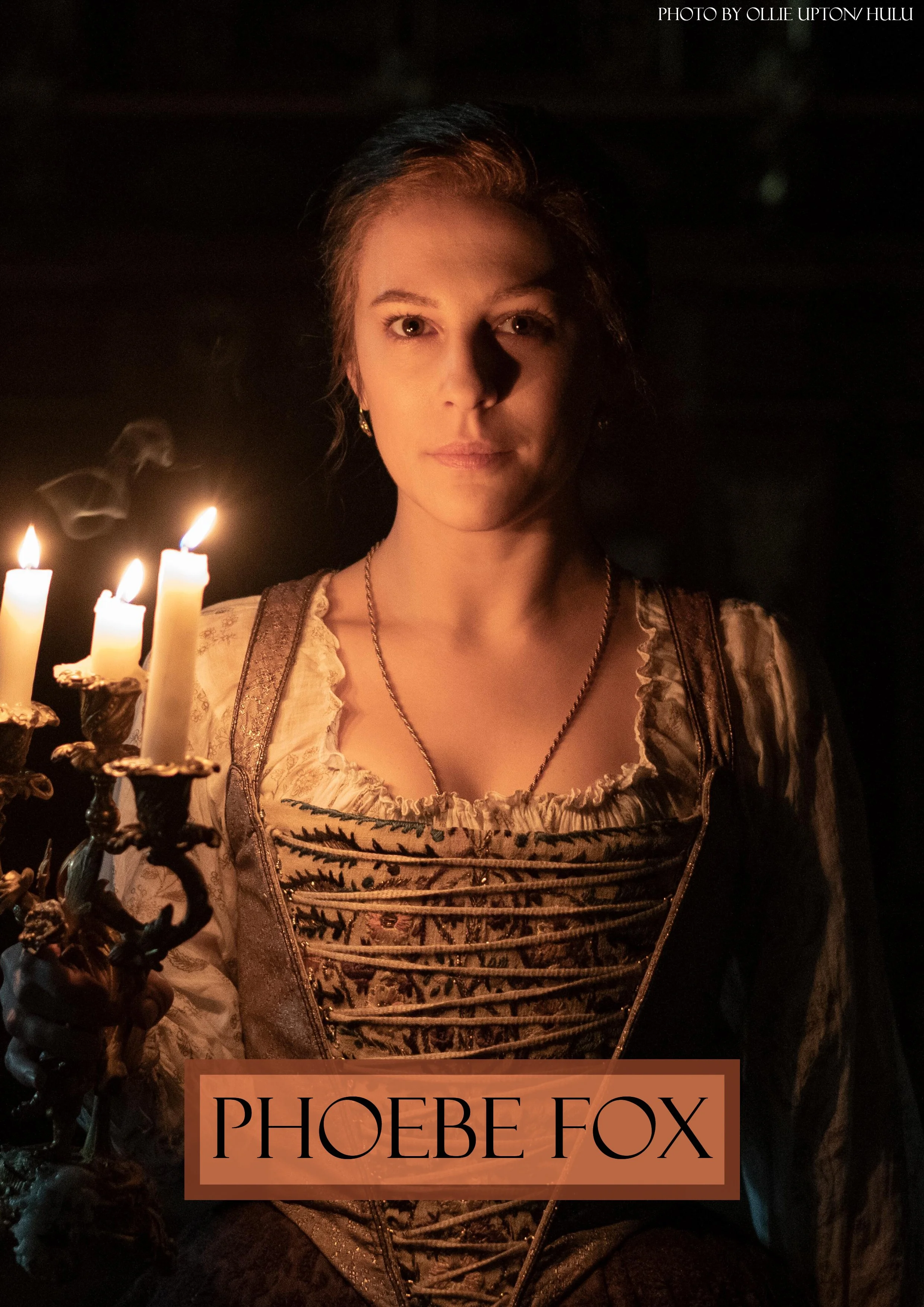 A woman dressed in a traditional German dirndl holding a candelabrum with lit candles. Text overlay reads 'Phoebe Fox' and photo credit to Ollie Upton/Hulu.
