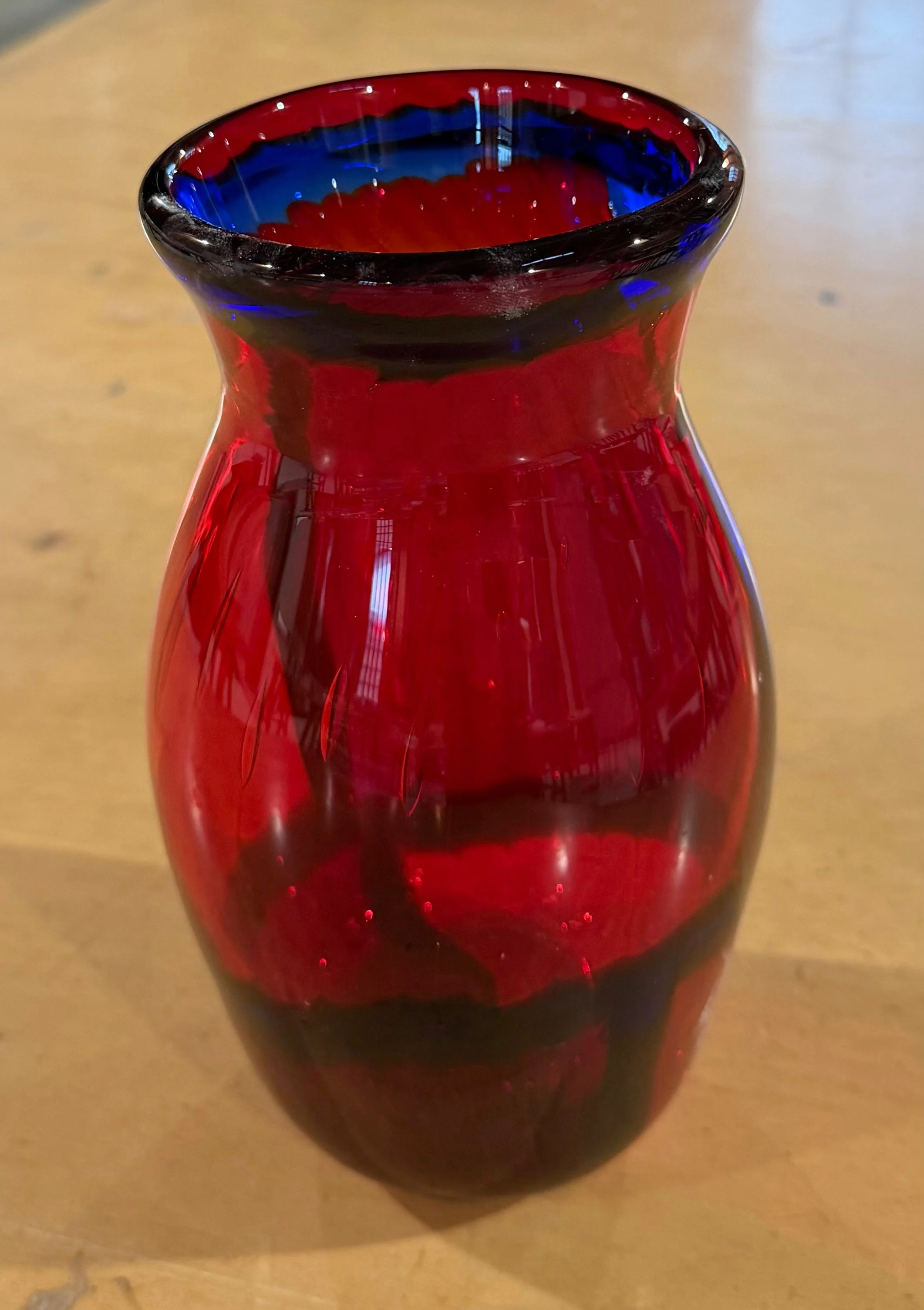 Handblown glass vase: Transparent red with blue circles and a blue stripe.