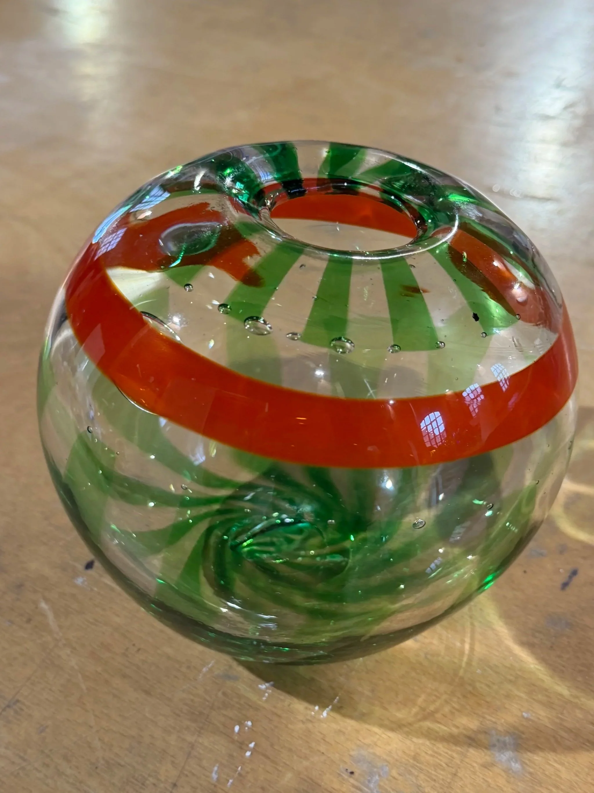 Handblown glass vase: Clear globe with green stripes and orange band.