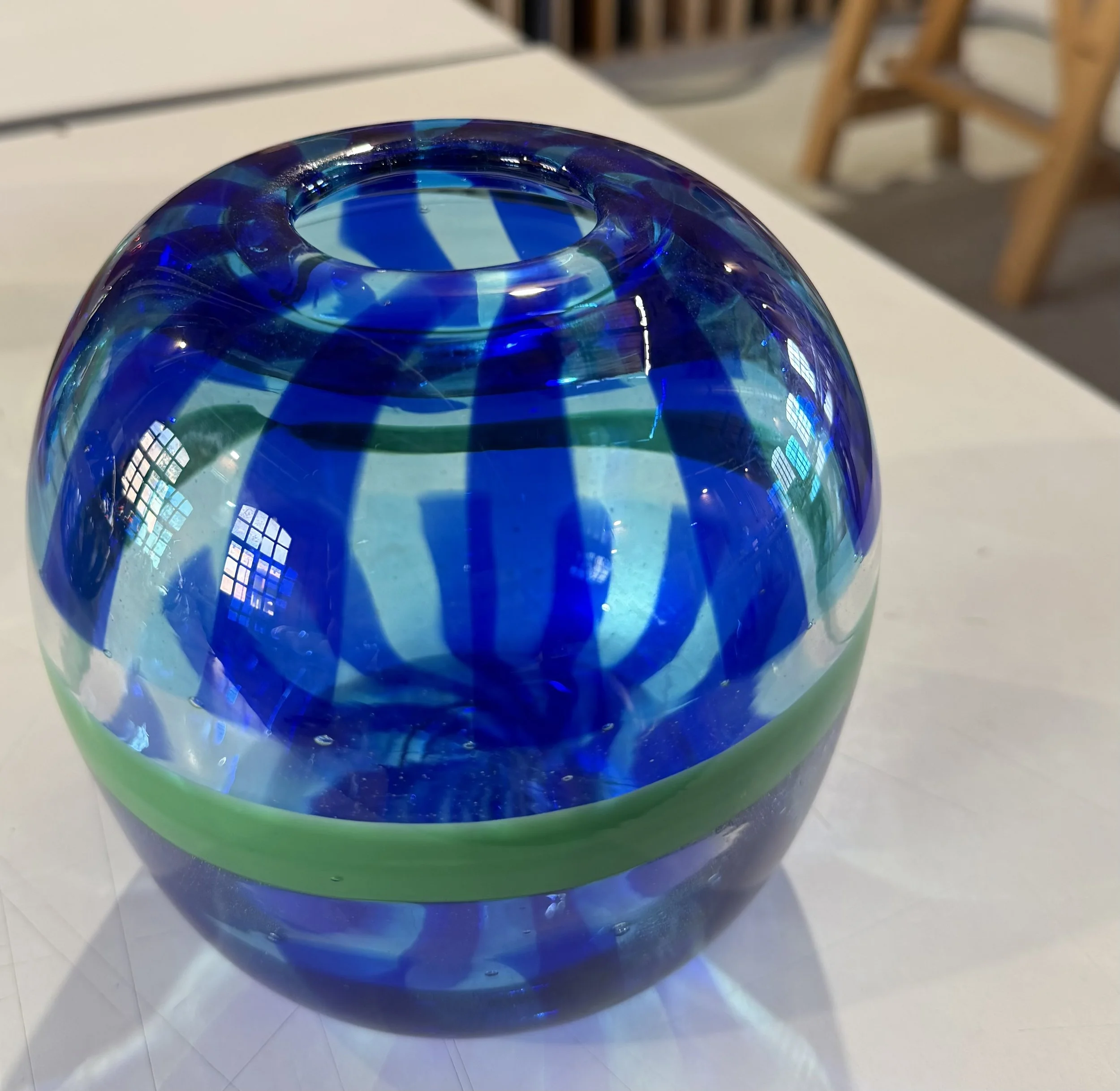 Handblown glass vase: Clear globe with blue stripes and green band.