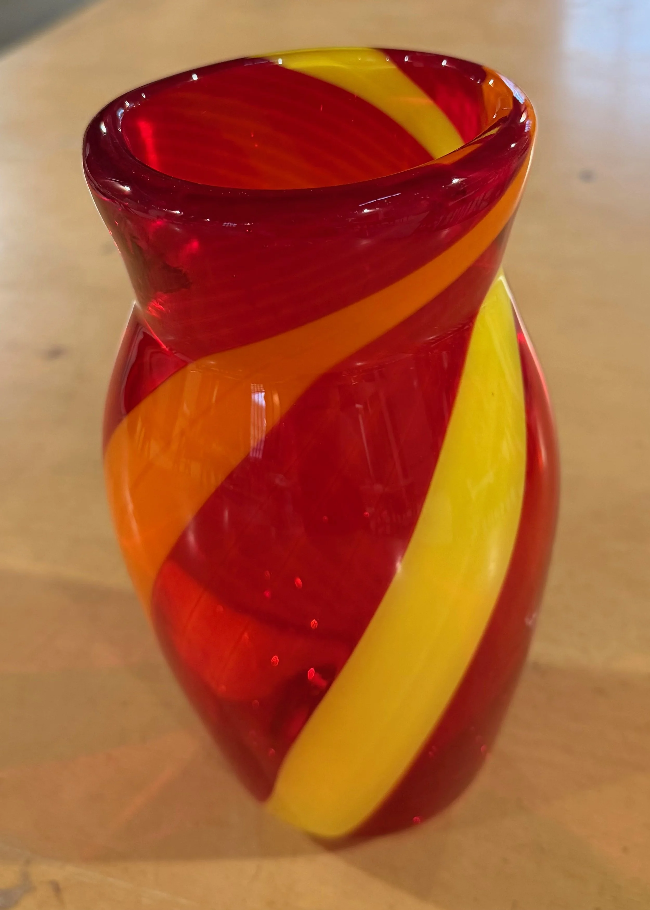 Handblown glass vase: Transparent red with orange and yellow bands.