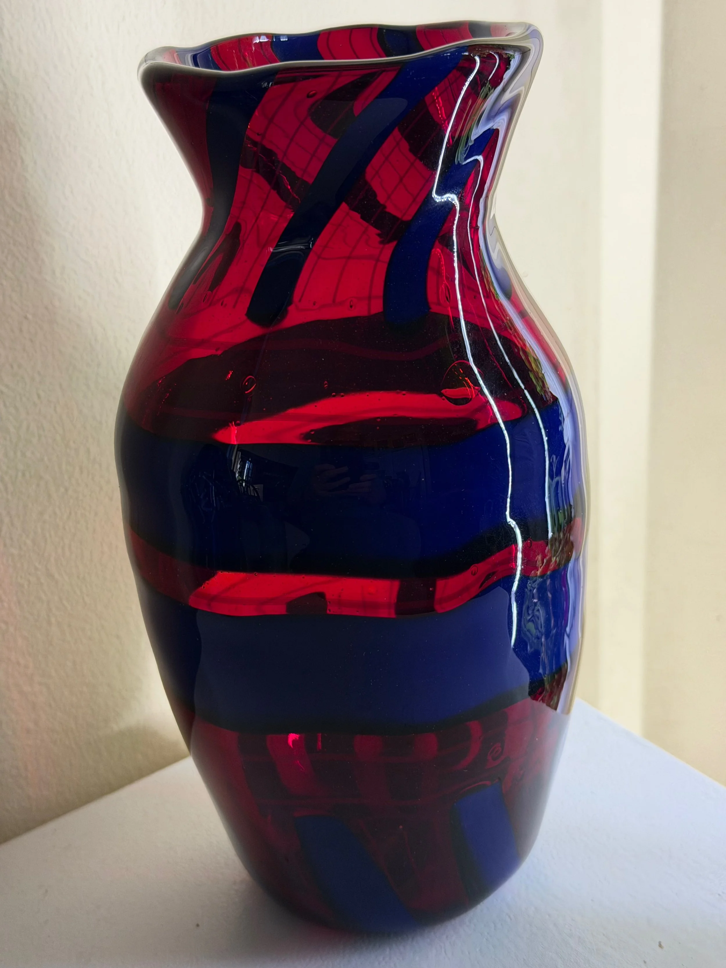 Handblown glass vase: Transparent red with transparent blue rings and stripes.