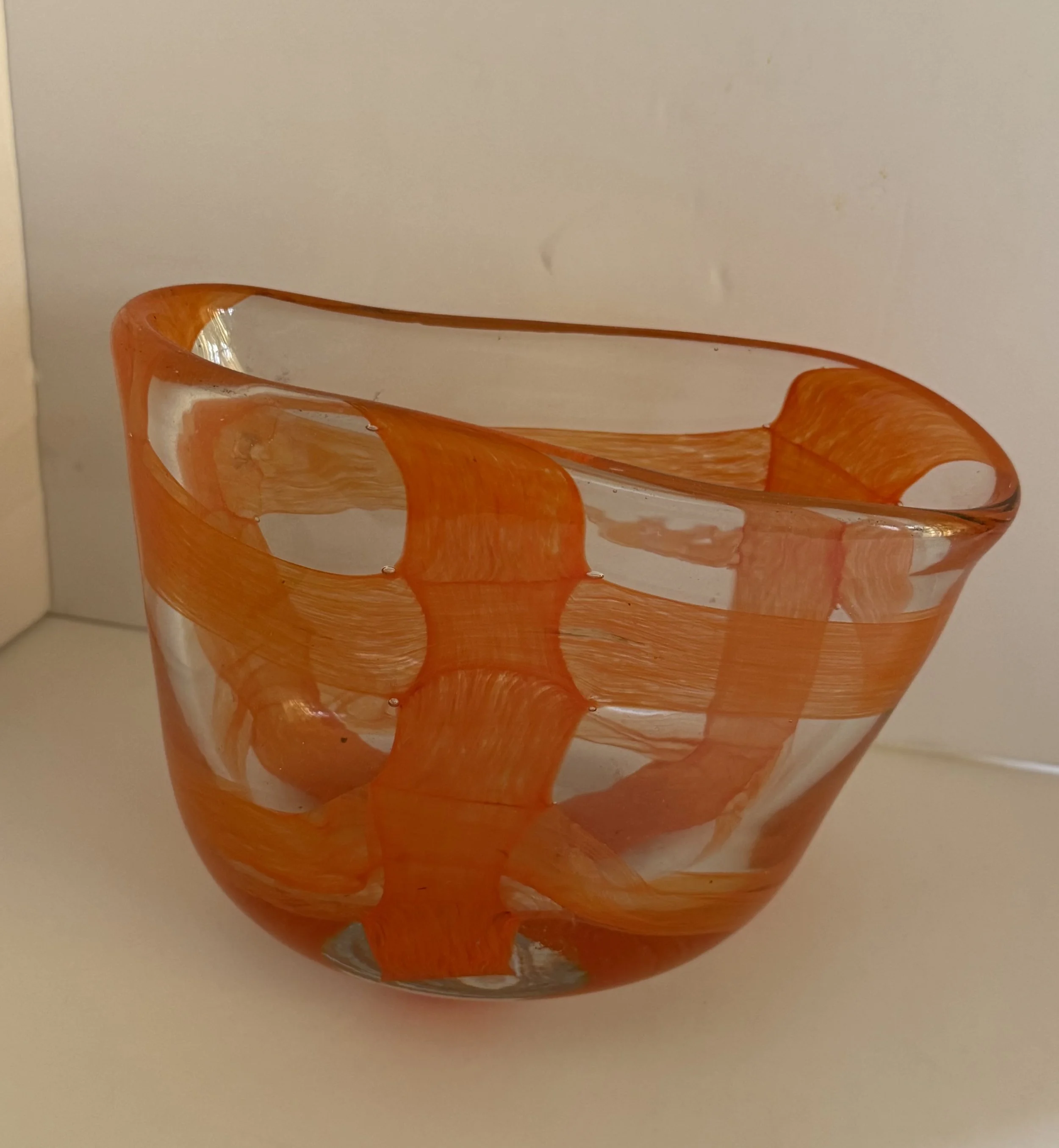 Handblown glass dish: Clear, asymmetrical dish with orange bands.