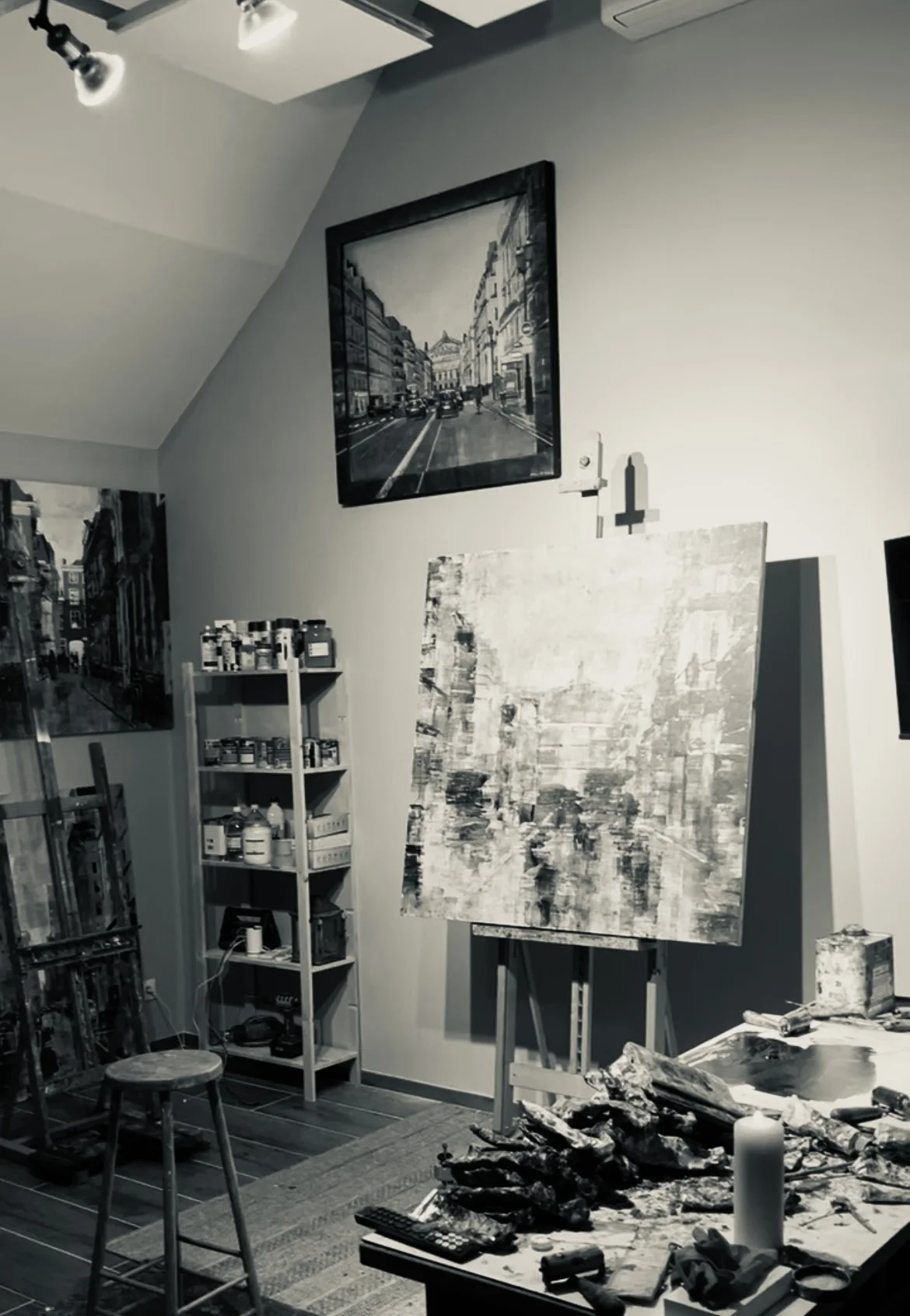 Atelier d'Adrien Faveau avec peintures, matériel et toile en cours de réalisation.