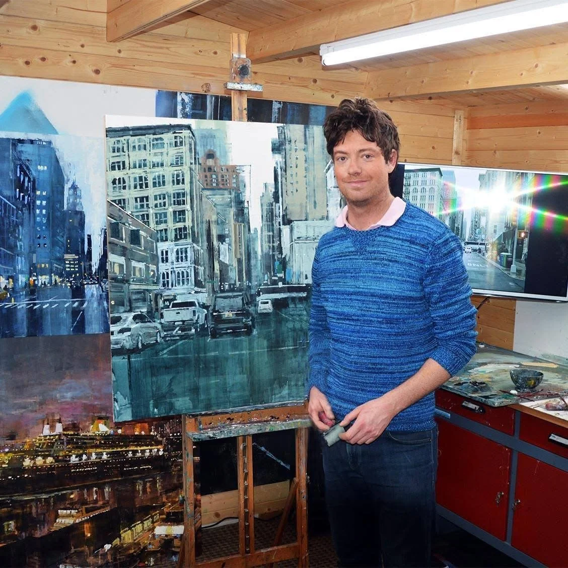 Adrien Faveau dans son atelier devant l'une de ses peintures urbaines