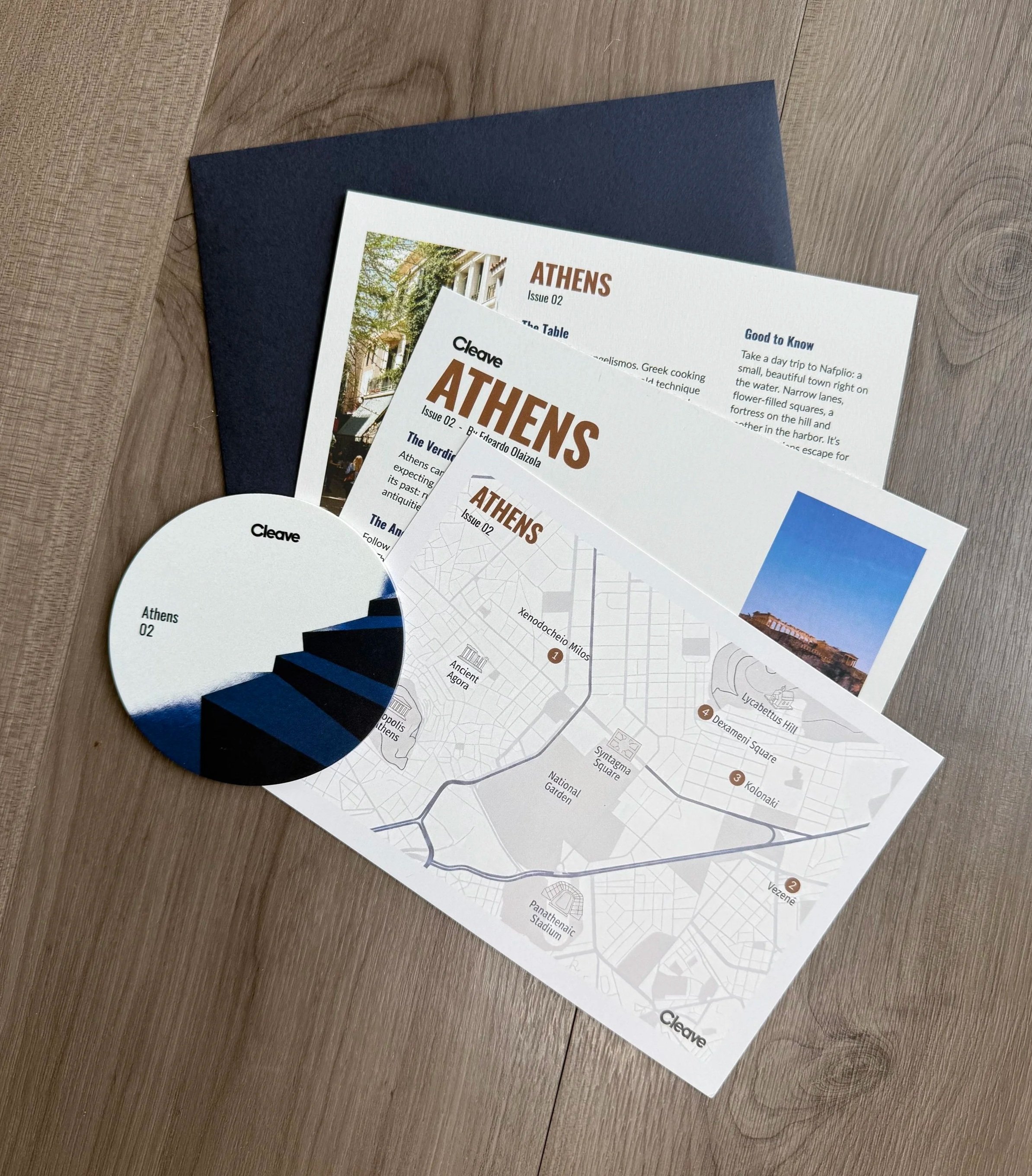 What's inside a Cleave snail mail club envelope: a 7×5 city card, a small map and a coaster
